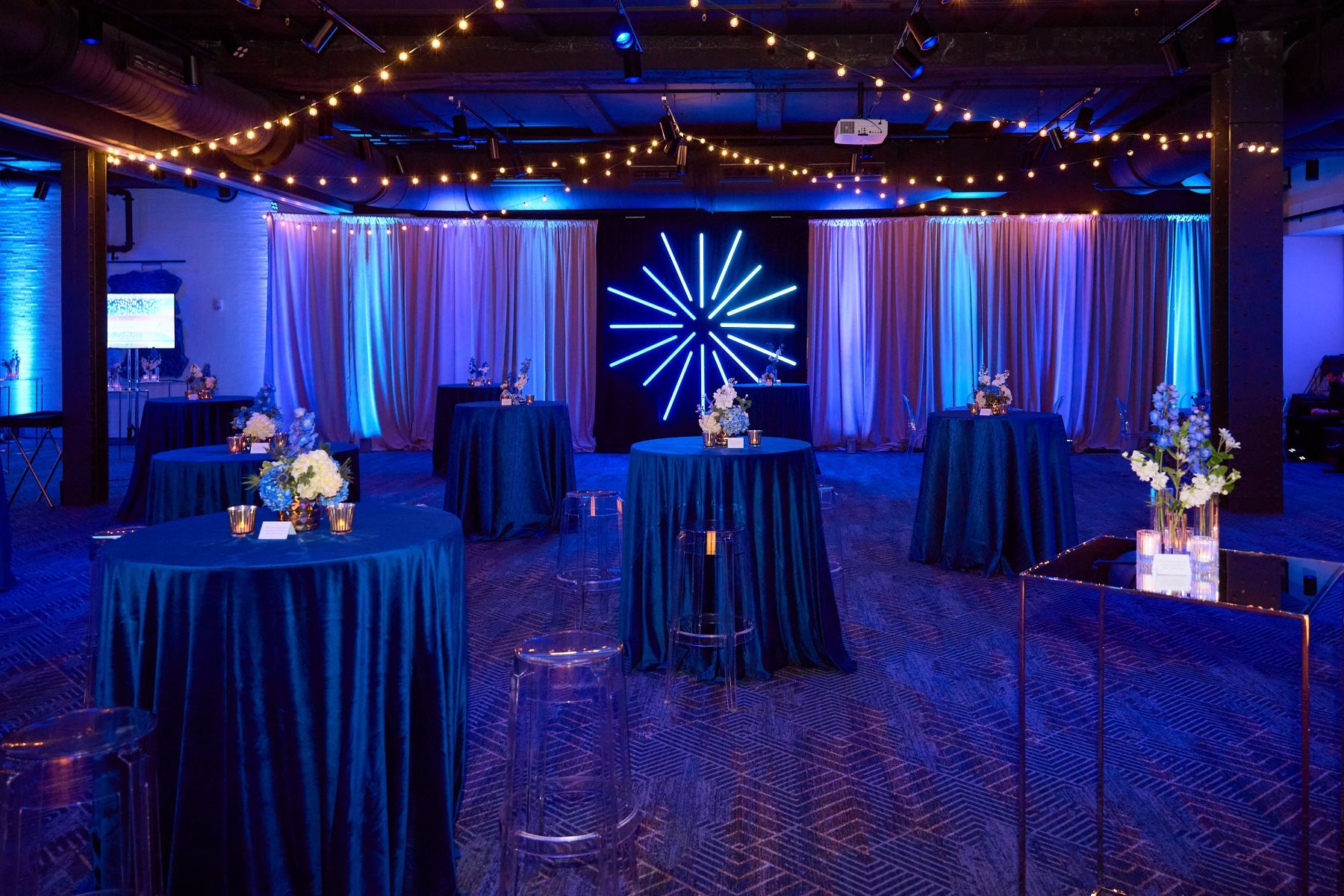 A large room with blue tables and a star on the wall.