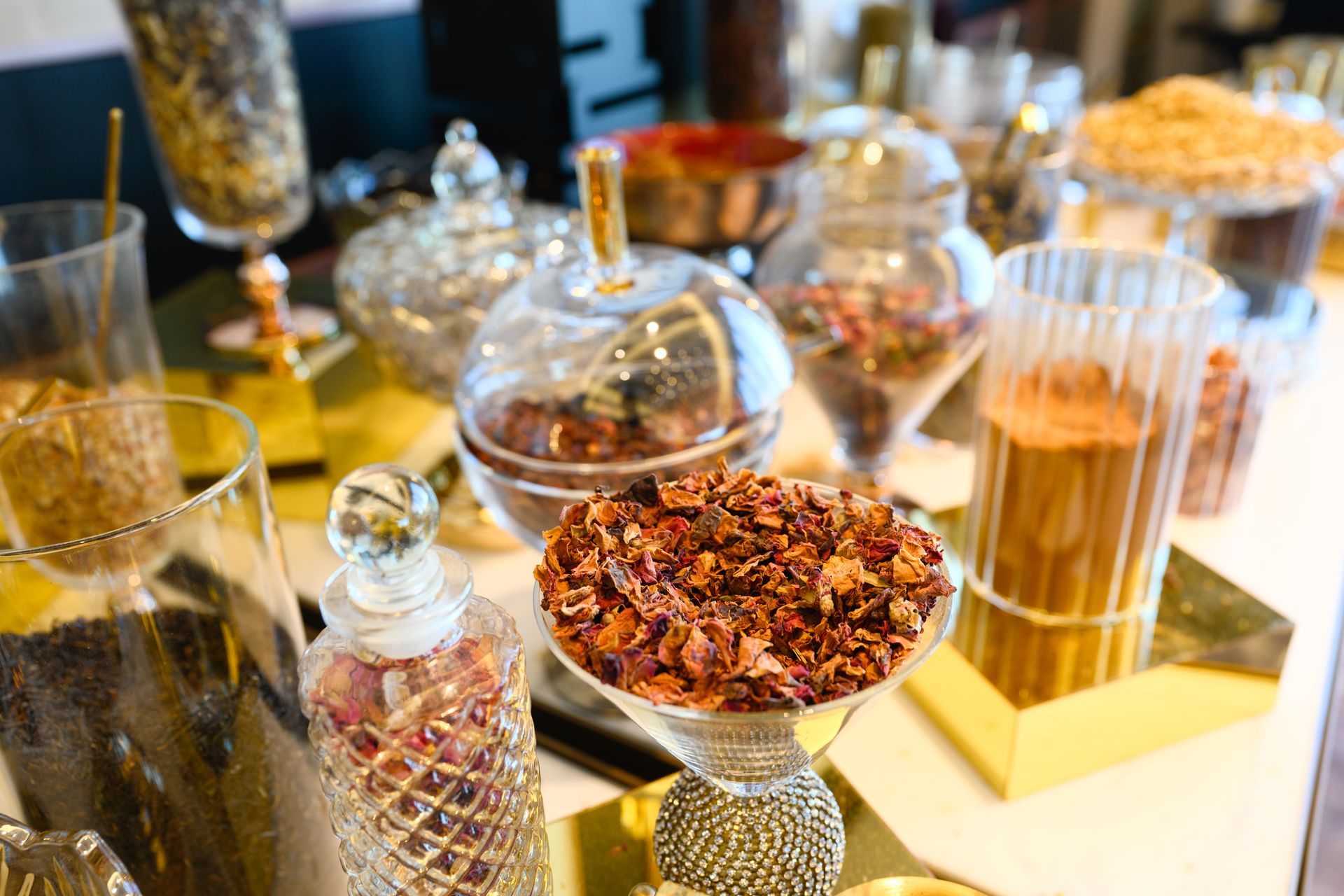 Assorted snacks in glass jars on a buffet table, including dried fruit and breadsticks.