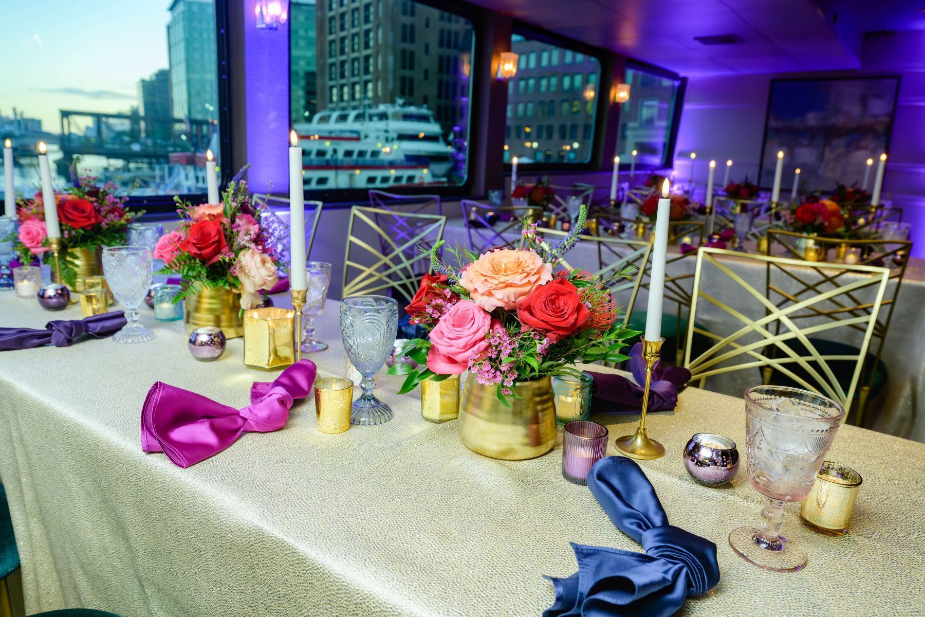 A long table with flowers and candles on it.