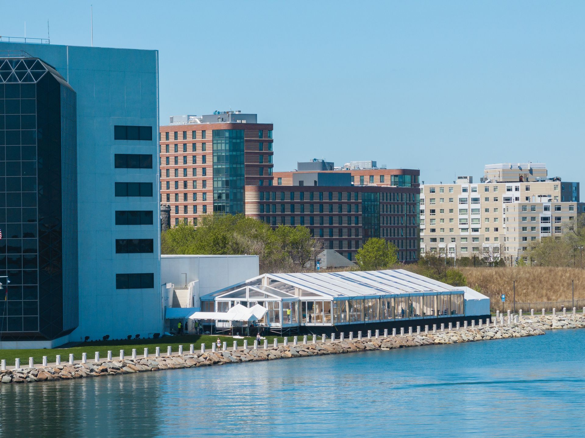 A large building sits next to a body of water