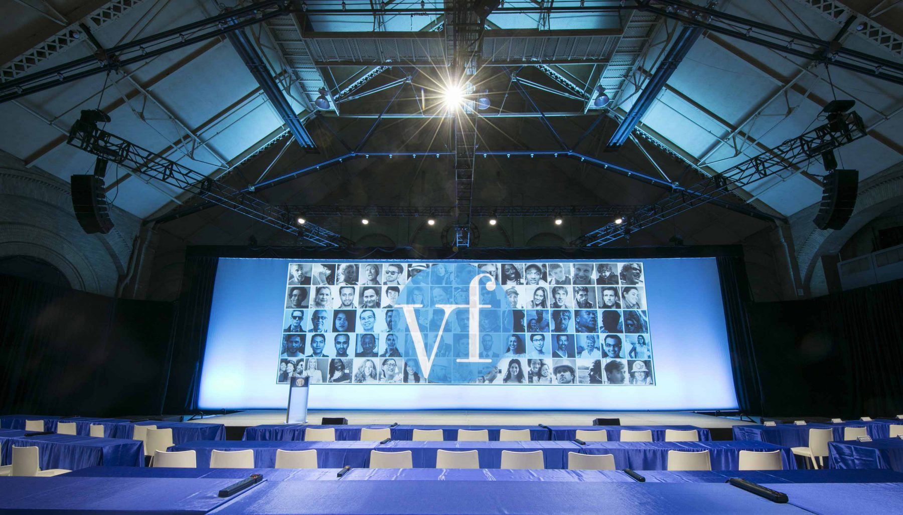 An empty auditorium with a large screen that says vf on it