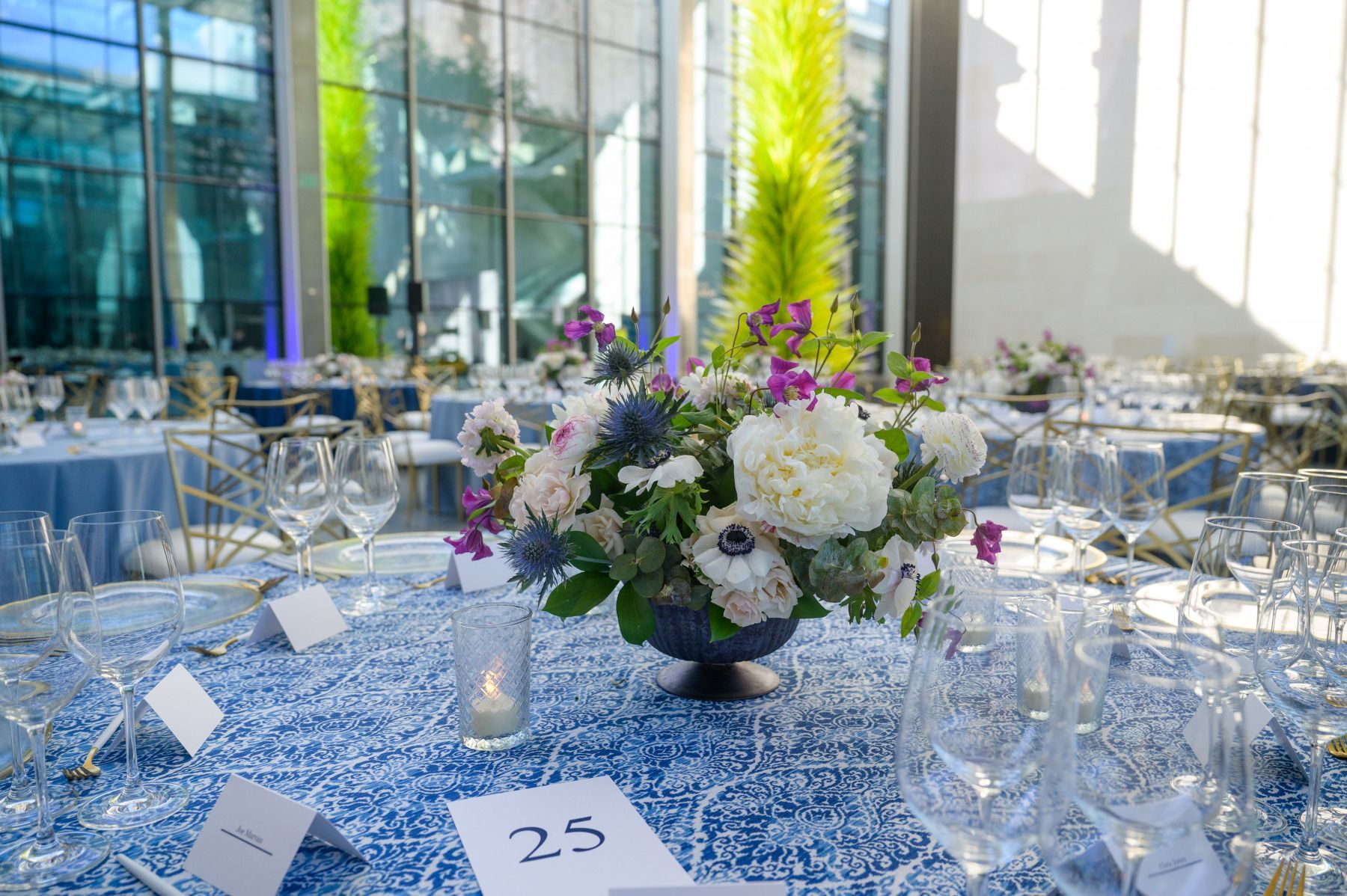 A table set for a dinner party with a vase of flowers on it.