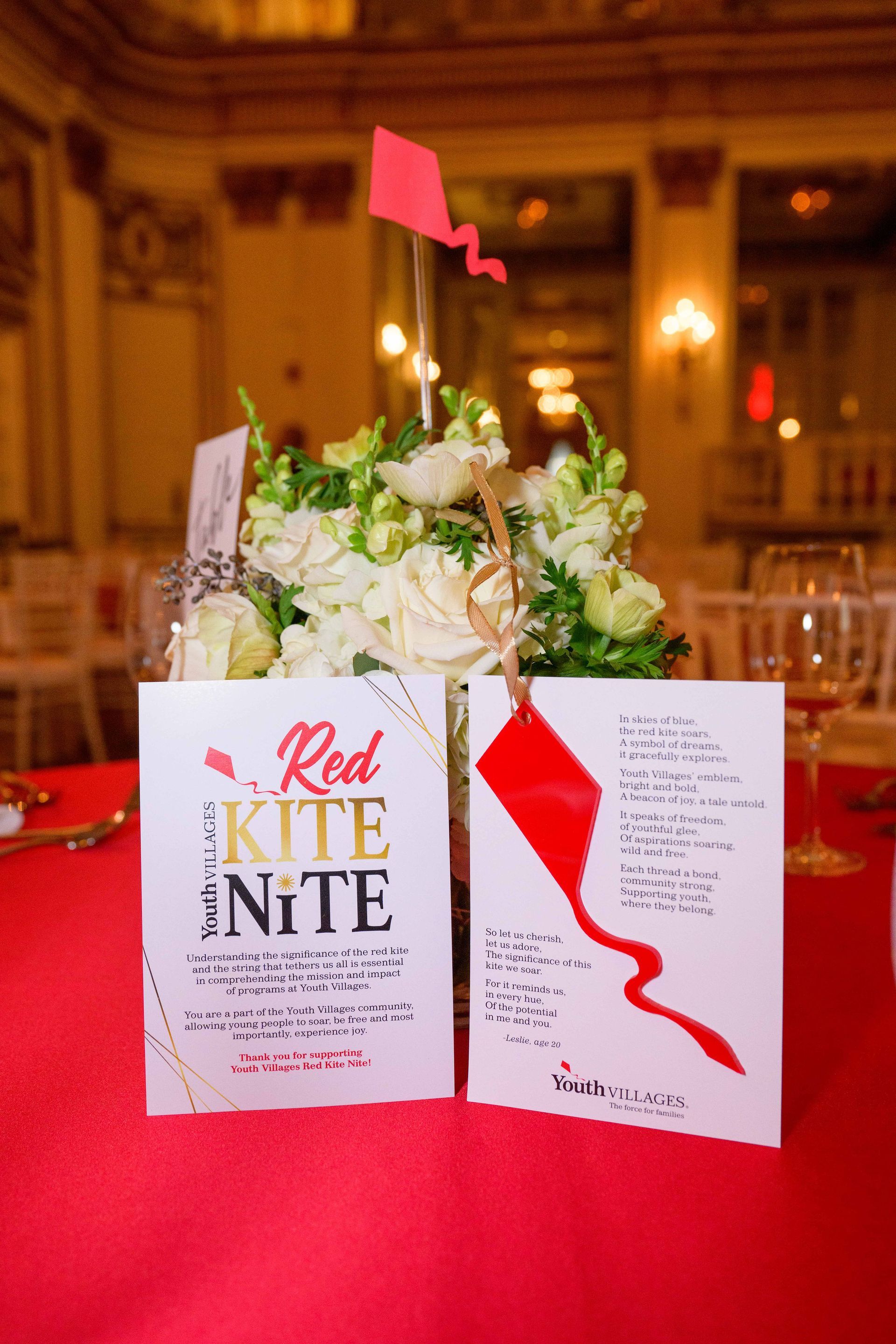 Centerpiece with white flowers, red table cloth, 