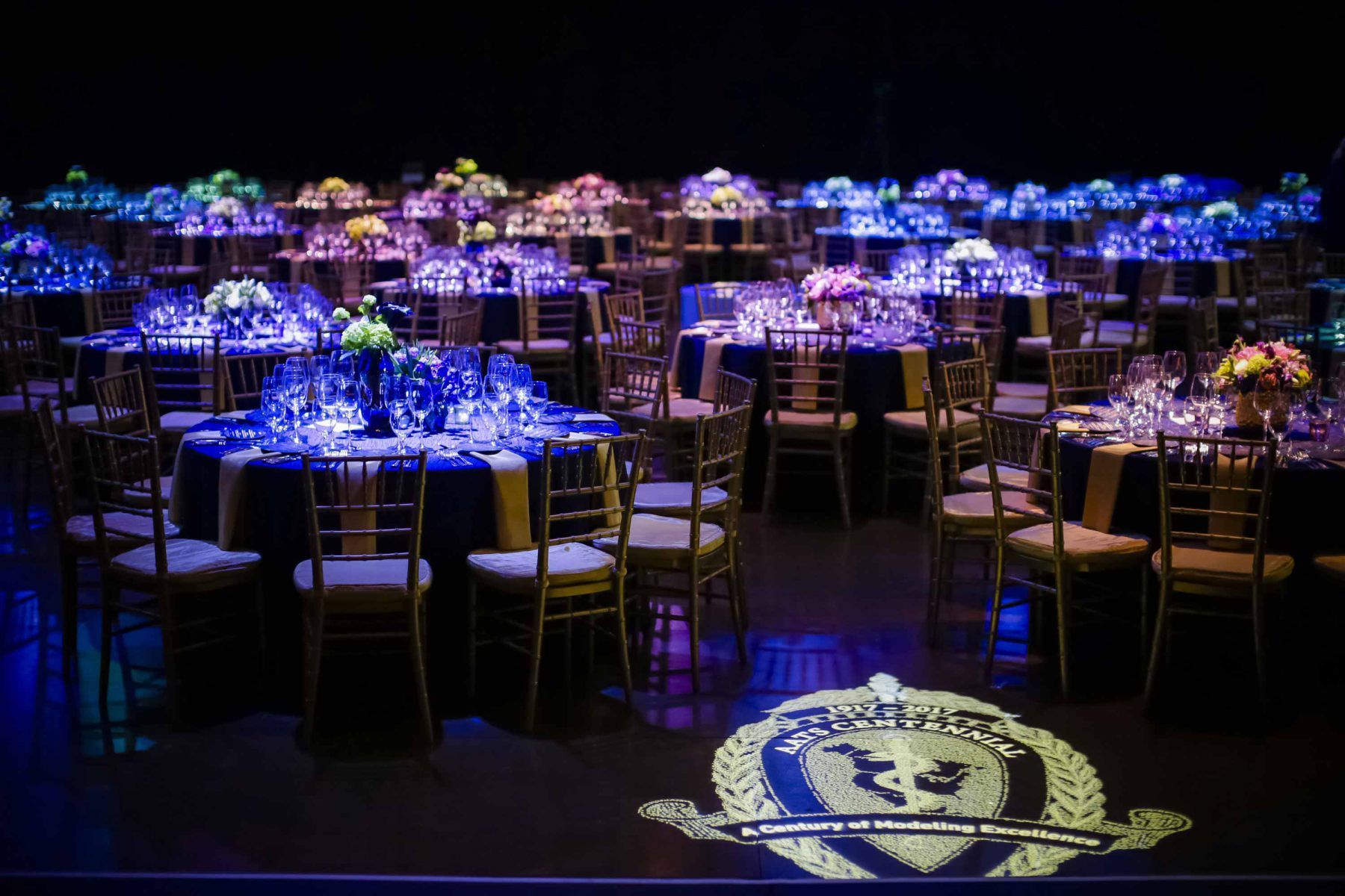 A large room with tables and chairs set up for a party.