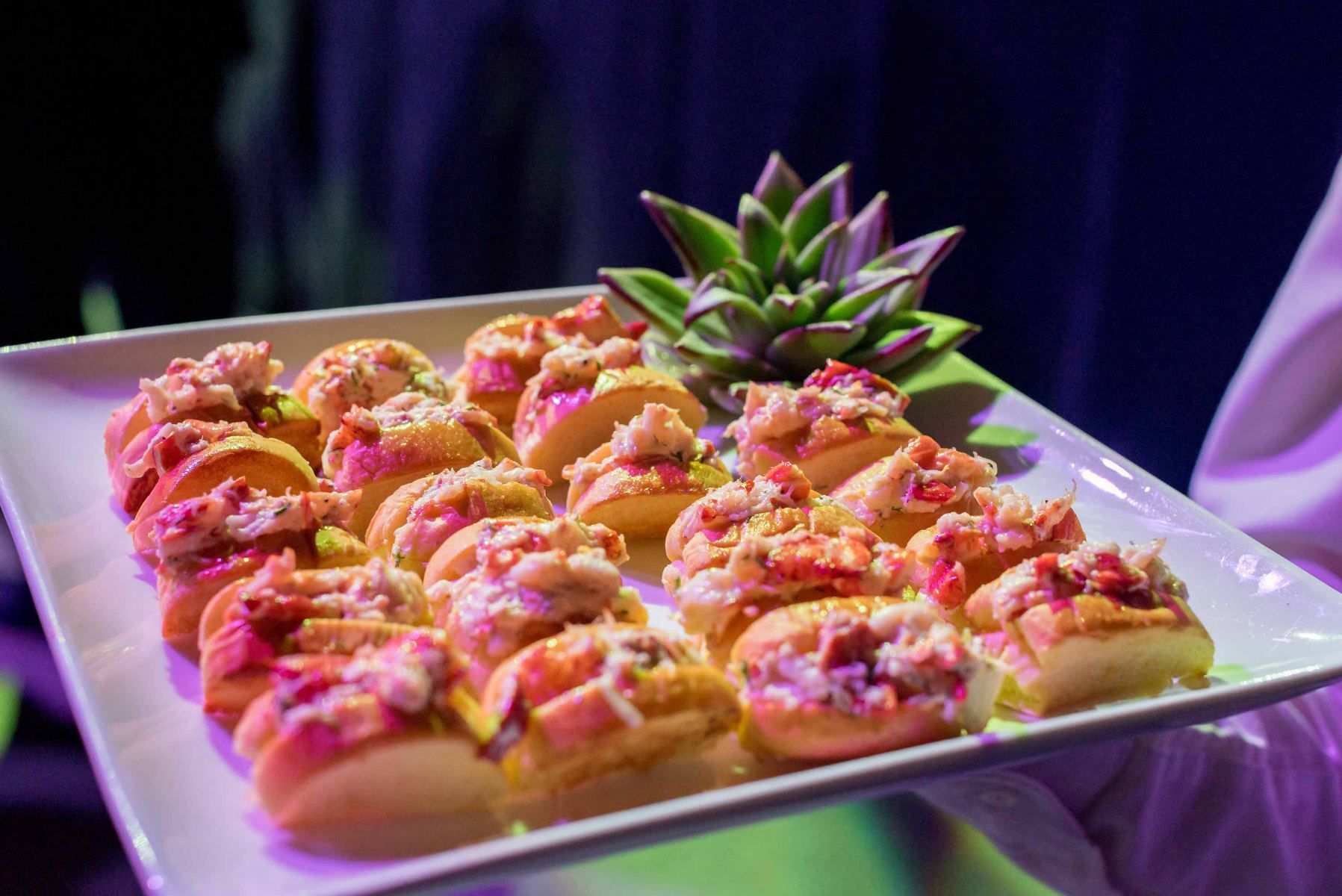 A person is holding a plate of food with a pineapple on top.