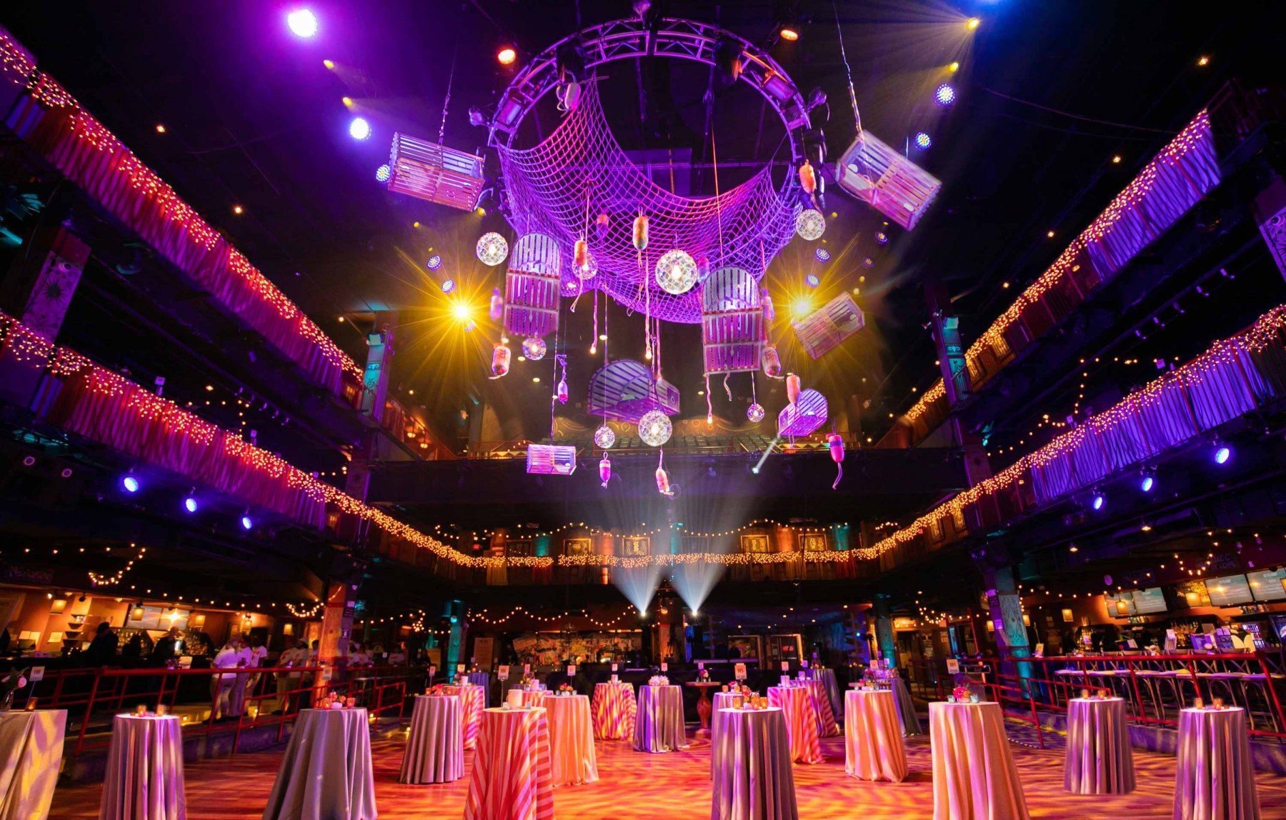 A large room with tables and a chandelier hanging from the ceiling.