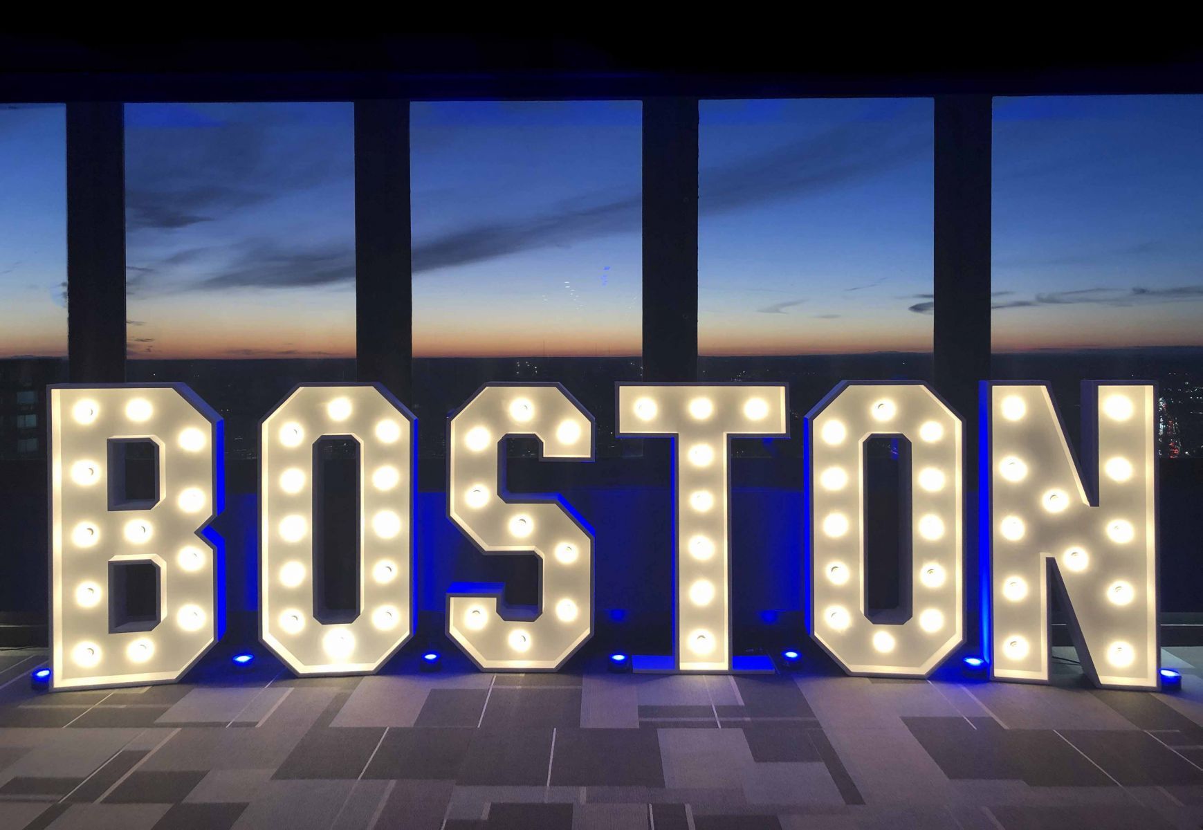 A large boston sign is lit up at night