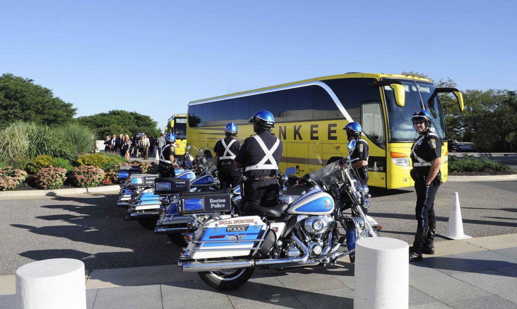 A bunch of police officers are standing in front of a yankee bus