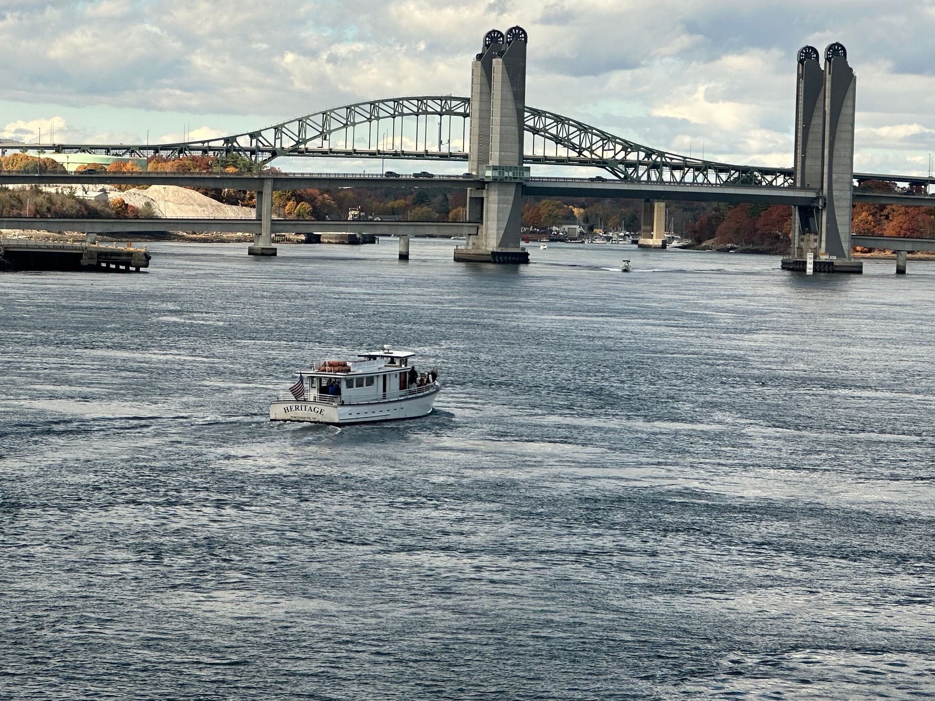 A bridge over a body of water with a boat in the foreground