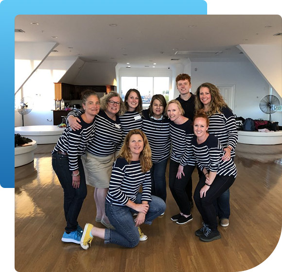 A group of people wearing striped shirts are posing for a picture