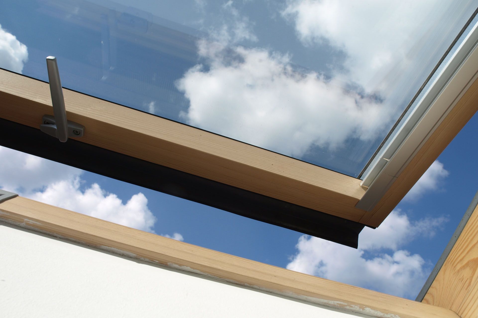 Looking through a skylight at a blue sky with white clouds