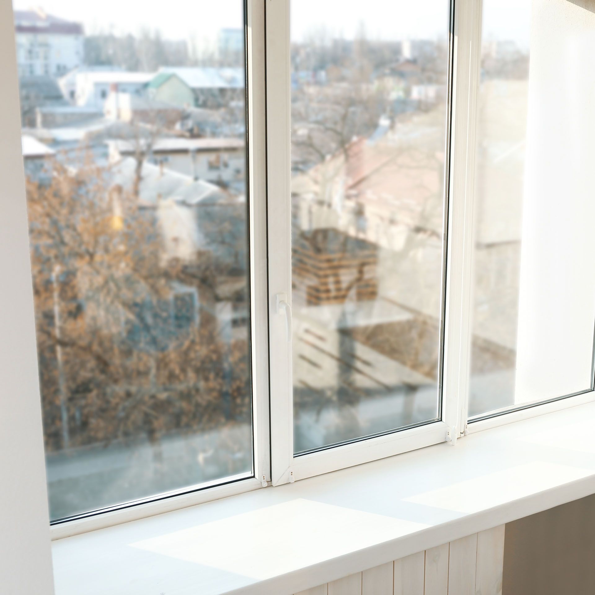 A close-up of a window with a view of a city.