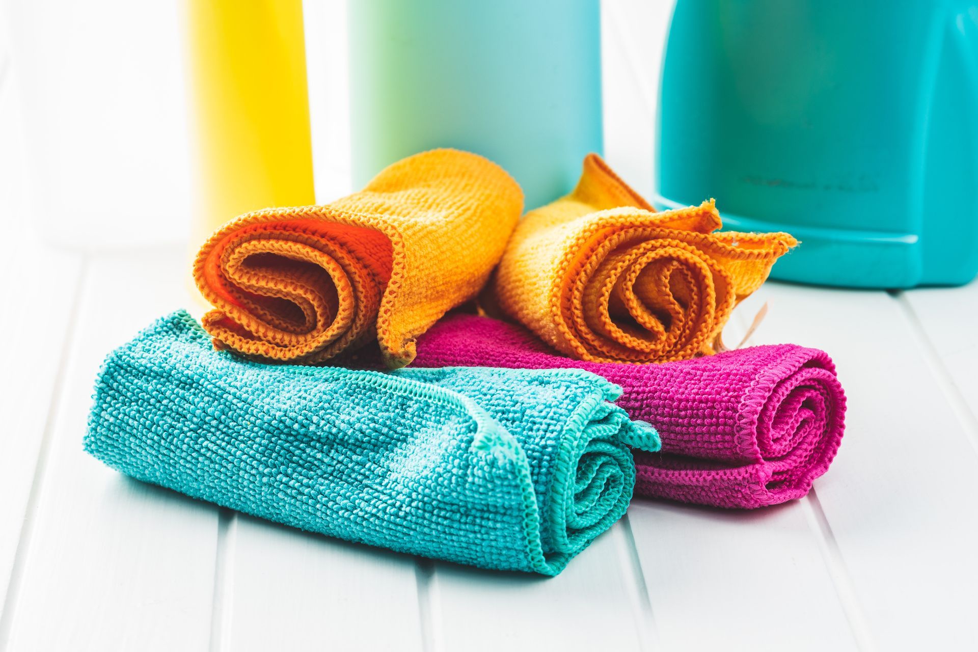 A bunch of microfibre towels are stacked on top of each other on a table.