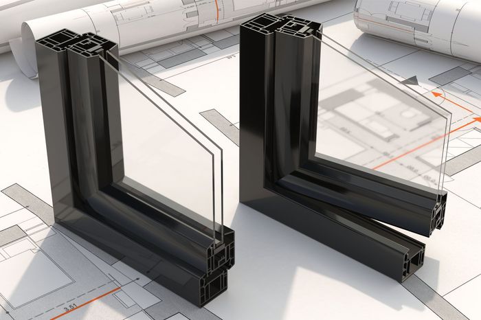 Portions of black windows are sitting on top of a blueprint.