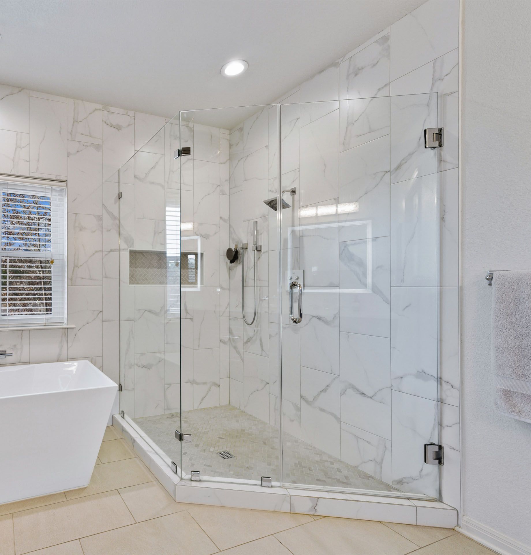 A bathroom with a bathtub and a walk-in shower with a glass partition.