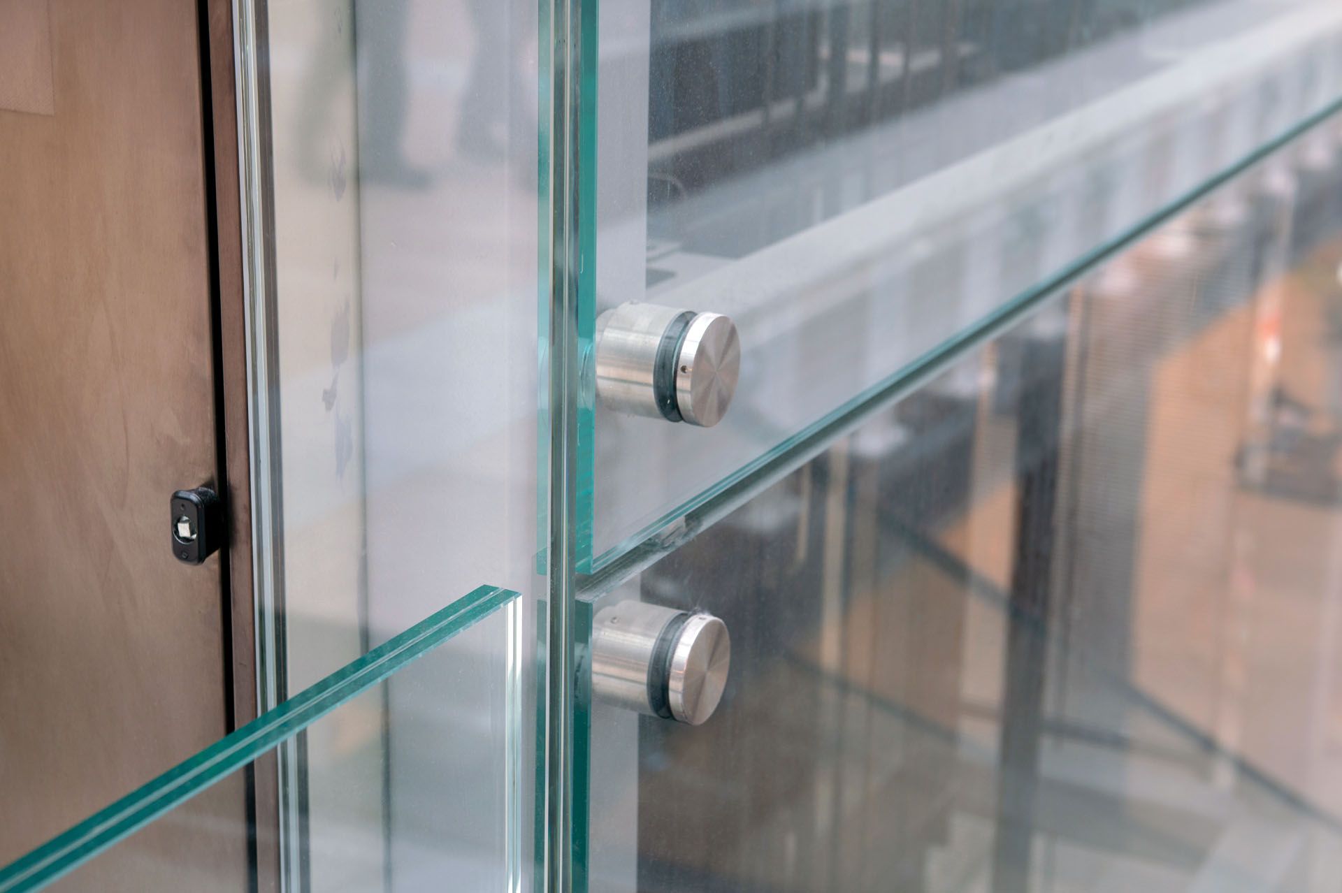 A close-up of a glass wall with stainless steel fittings.