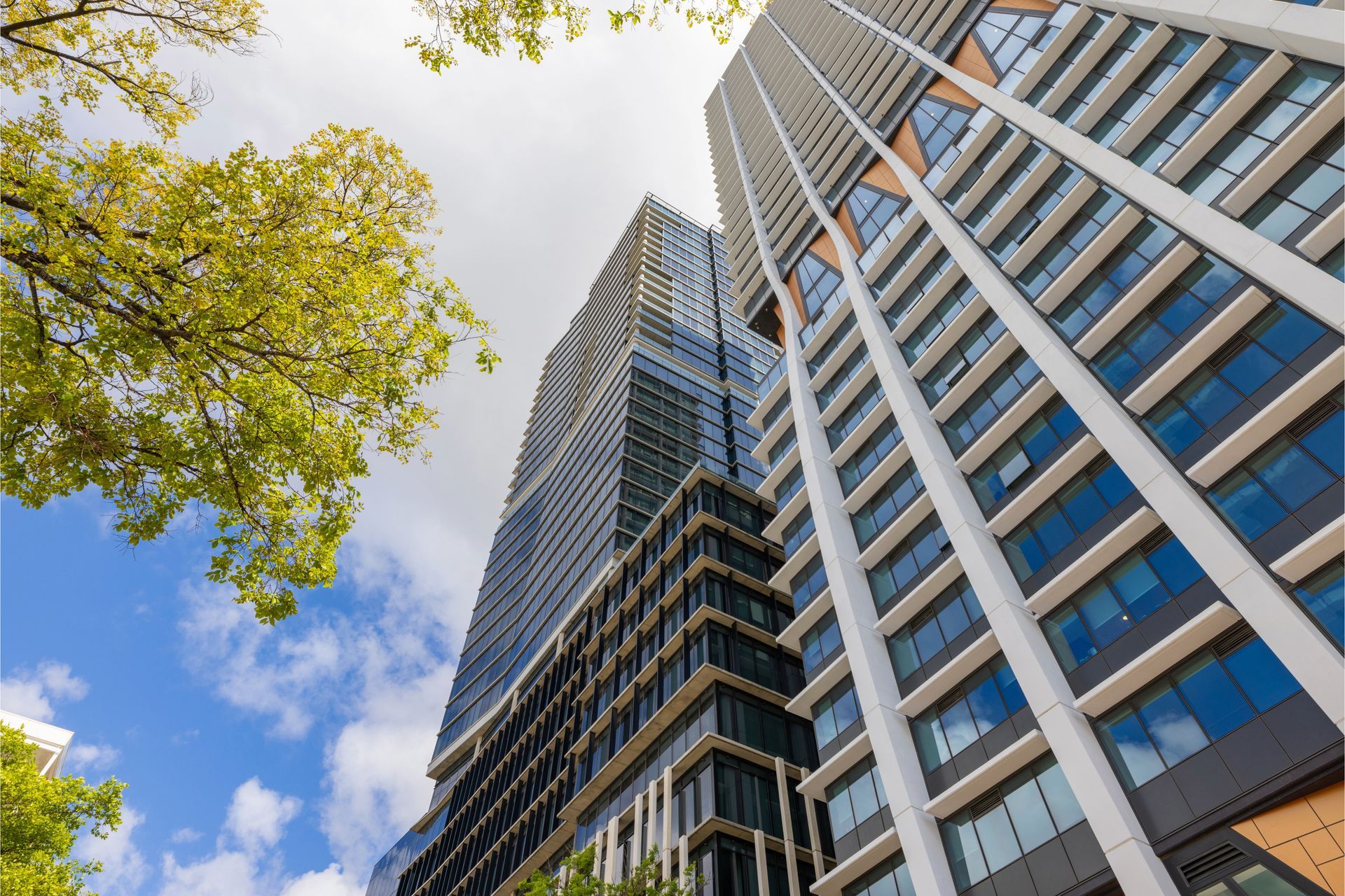 Looking up at a tall building with lots of windows on a sunny day.