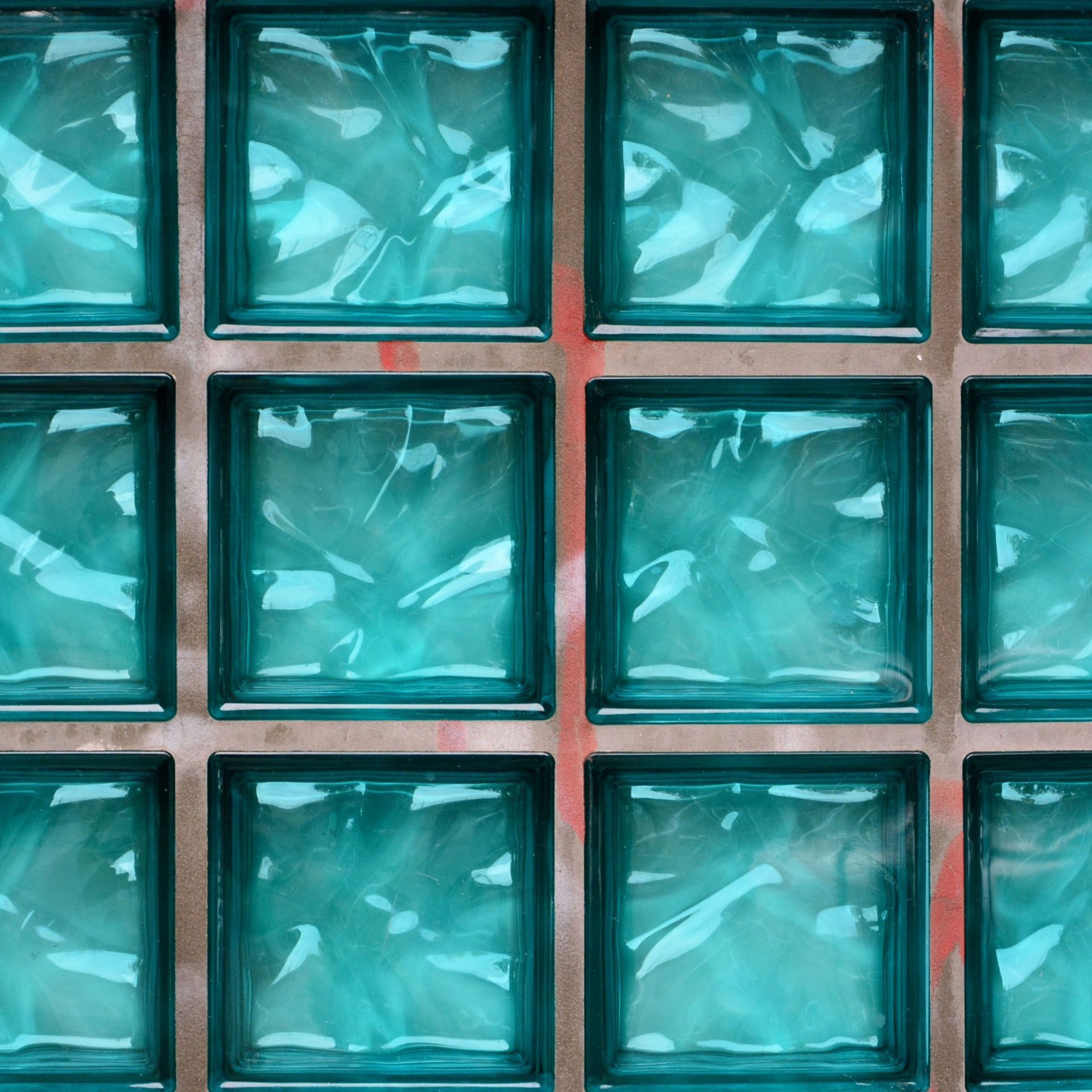 A close up of a wall made of blue glass blocks.