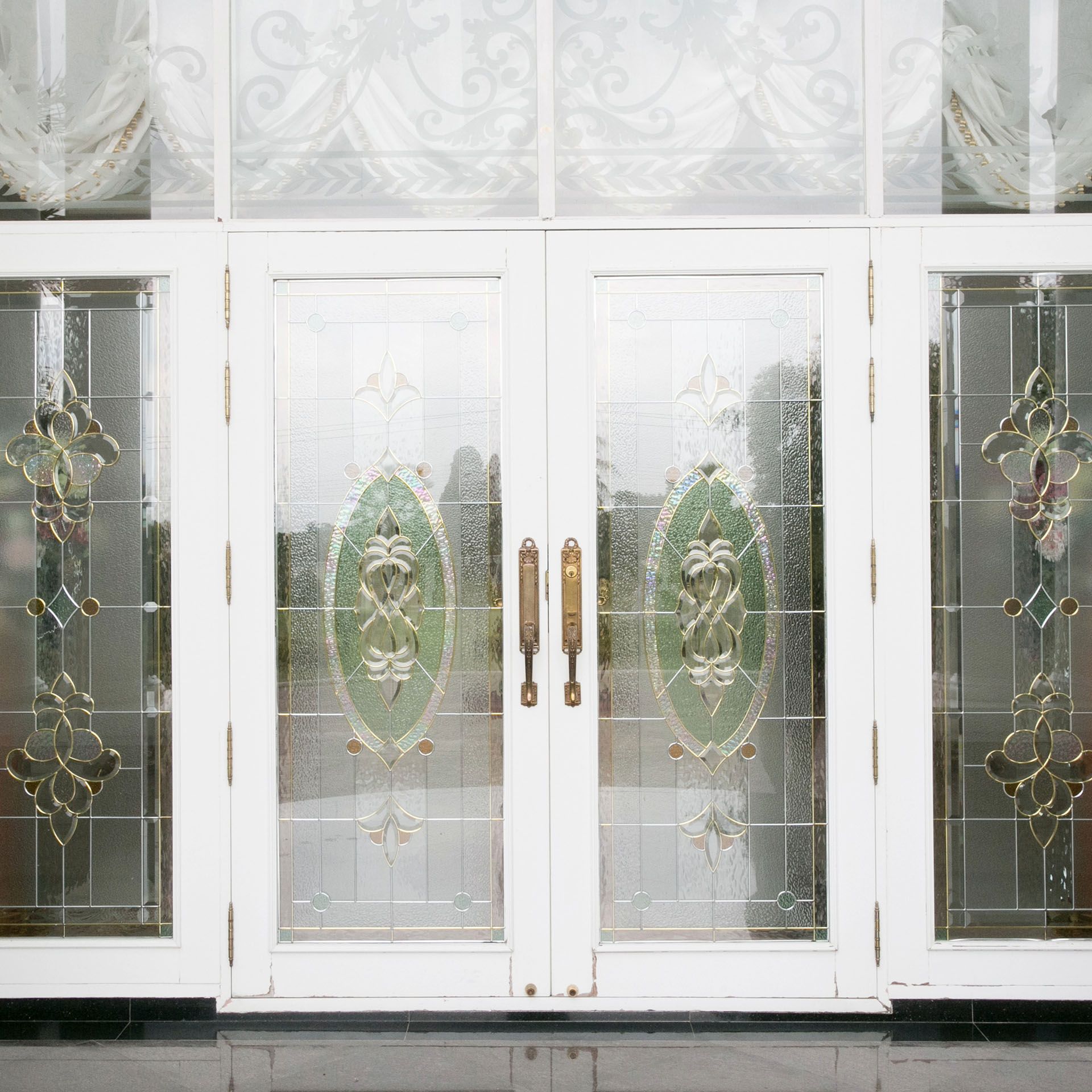 A white door with a stained glass design on it.