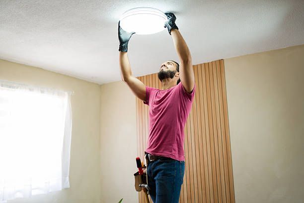 Electrician changing a light bulb.