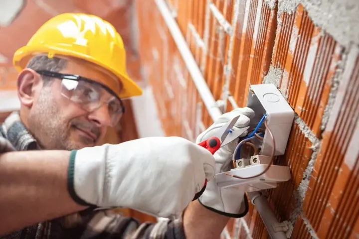 Electrician wiring a wall box