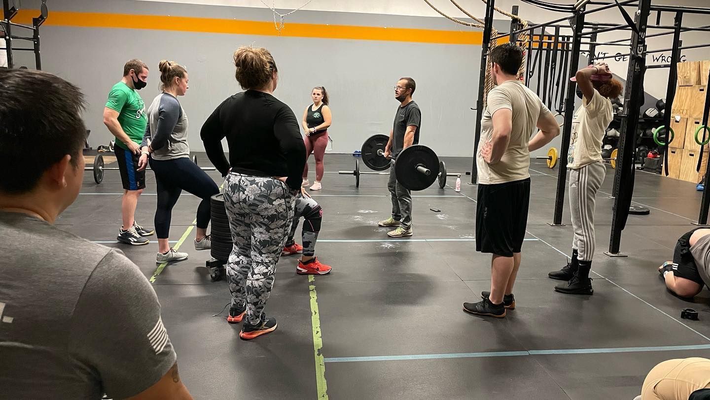 A group of people watching a coach holding a barbell at CrossFit Turbocharged gym in Cherry Hill, NJ