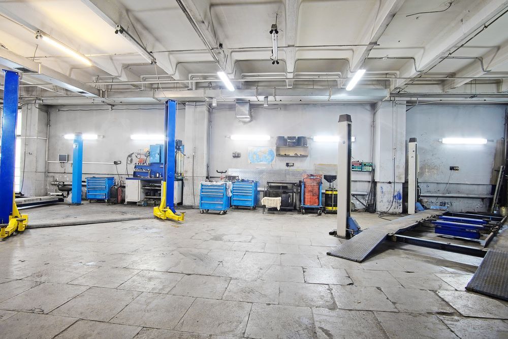 A Large Empty Garage with Two Lifts in It — Mahers Smash Repairs in Manilla, NSW