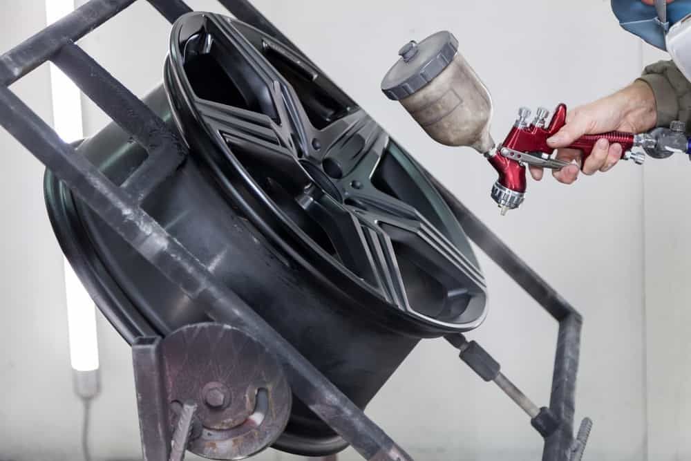 A Man Spray Painting A Wheel Mugs — Mahers Smash Repairs In Manilla, NSW