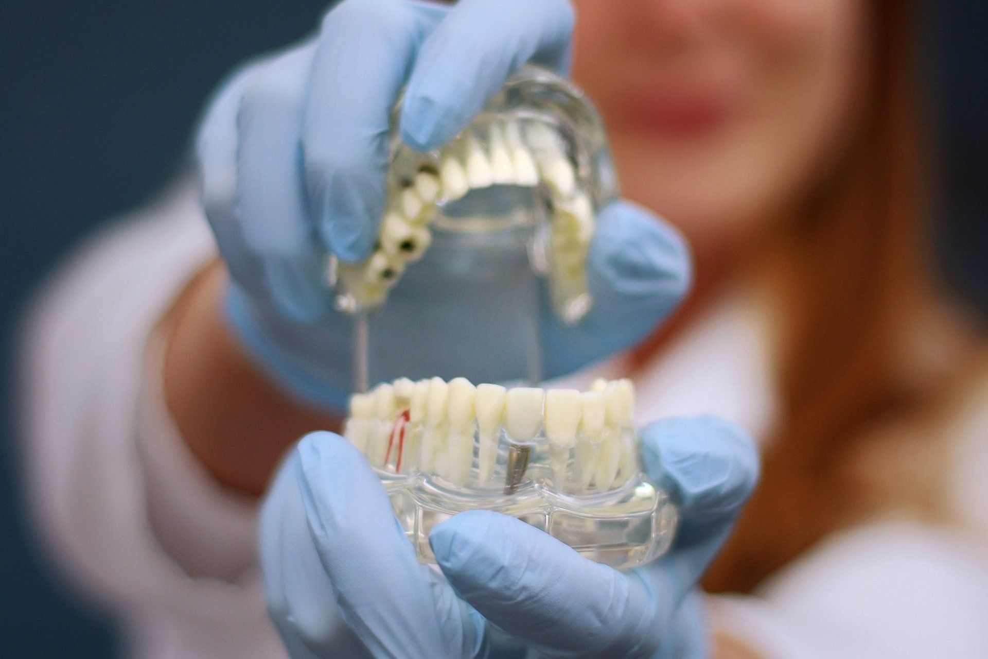 doctor holding dentures Dental Arts Studio of Cape COD