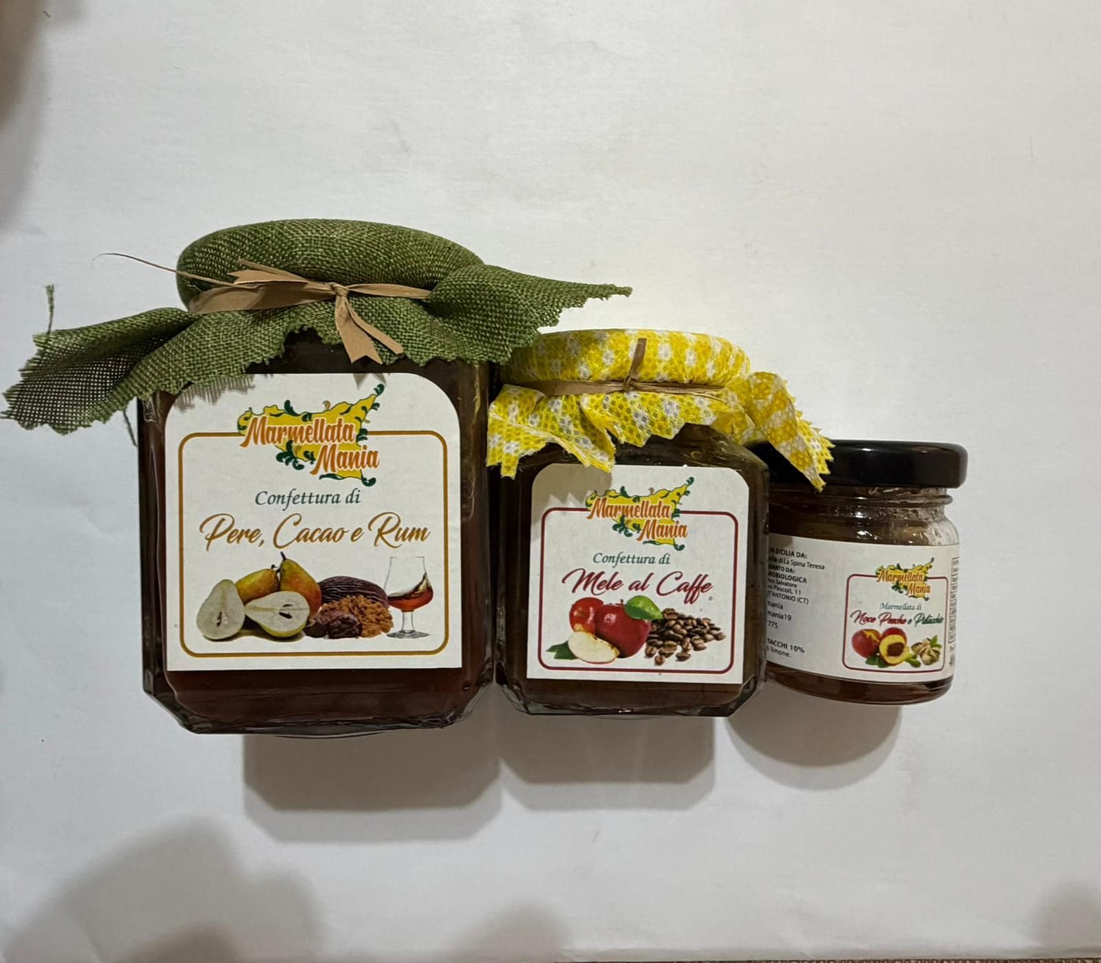 Tre vasetti di marmellata con coperchi decorativi in ​​tessuto su sfondo bianco.