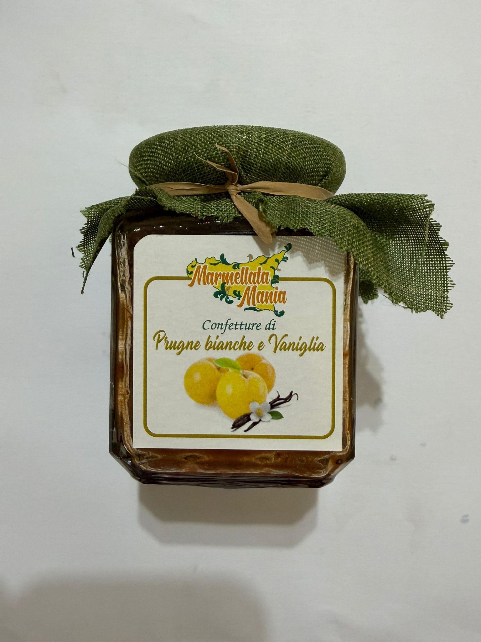 Vaso decorativo con piante finte e limoni su sfondo bianco.