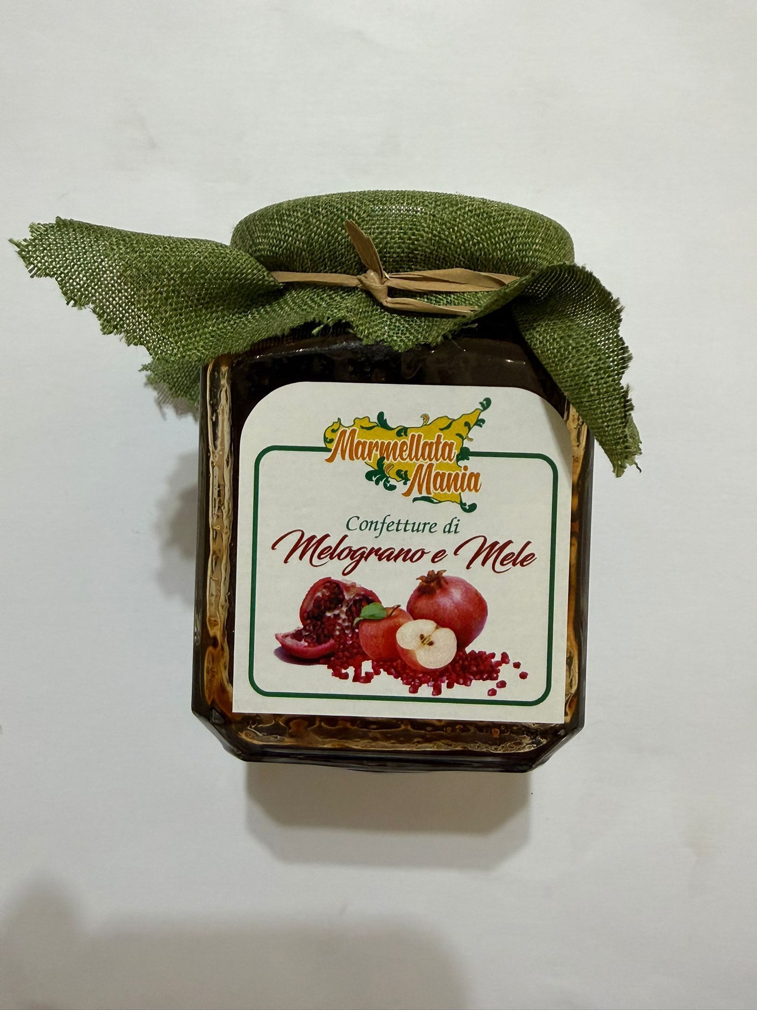 Vaso decorativo con foglie verdi ed etichetta con immagini di bacche rosse e frutta.