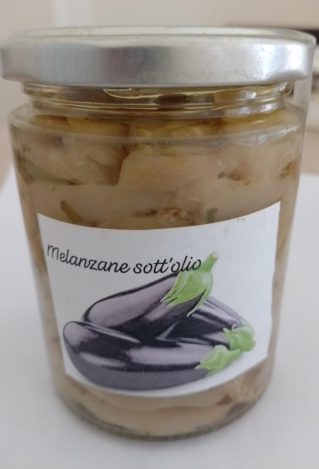 Vasetto di melanzane sott'aceto a fette con etichetta italiana e coperchio argentato.
