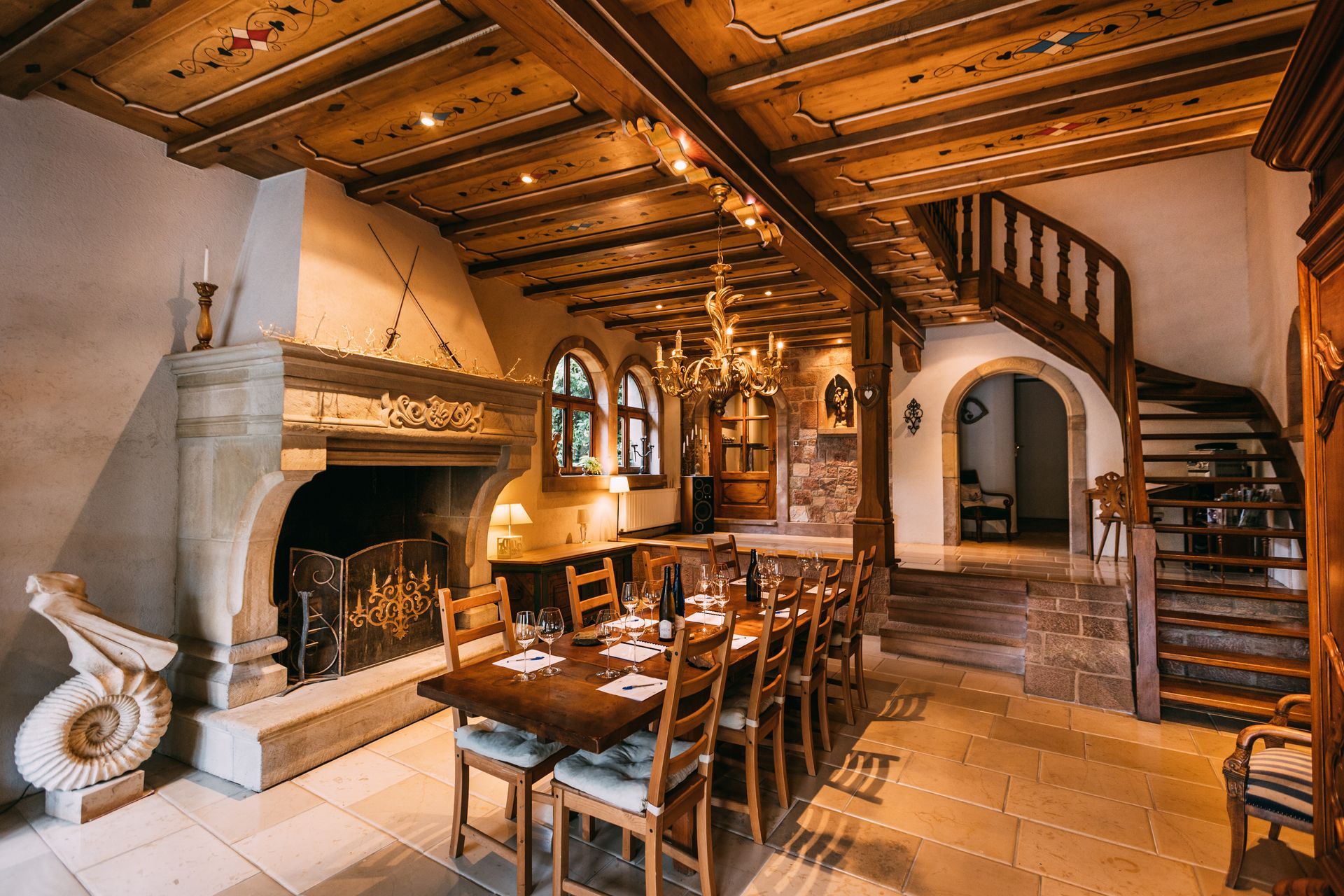 Une salle à manger avec une longue table et des chaises et une cheminée.