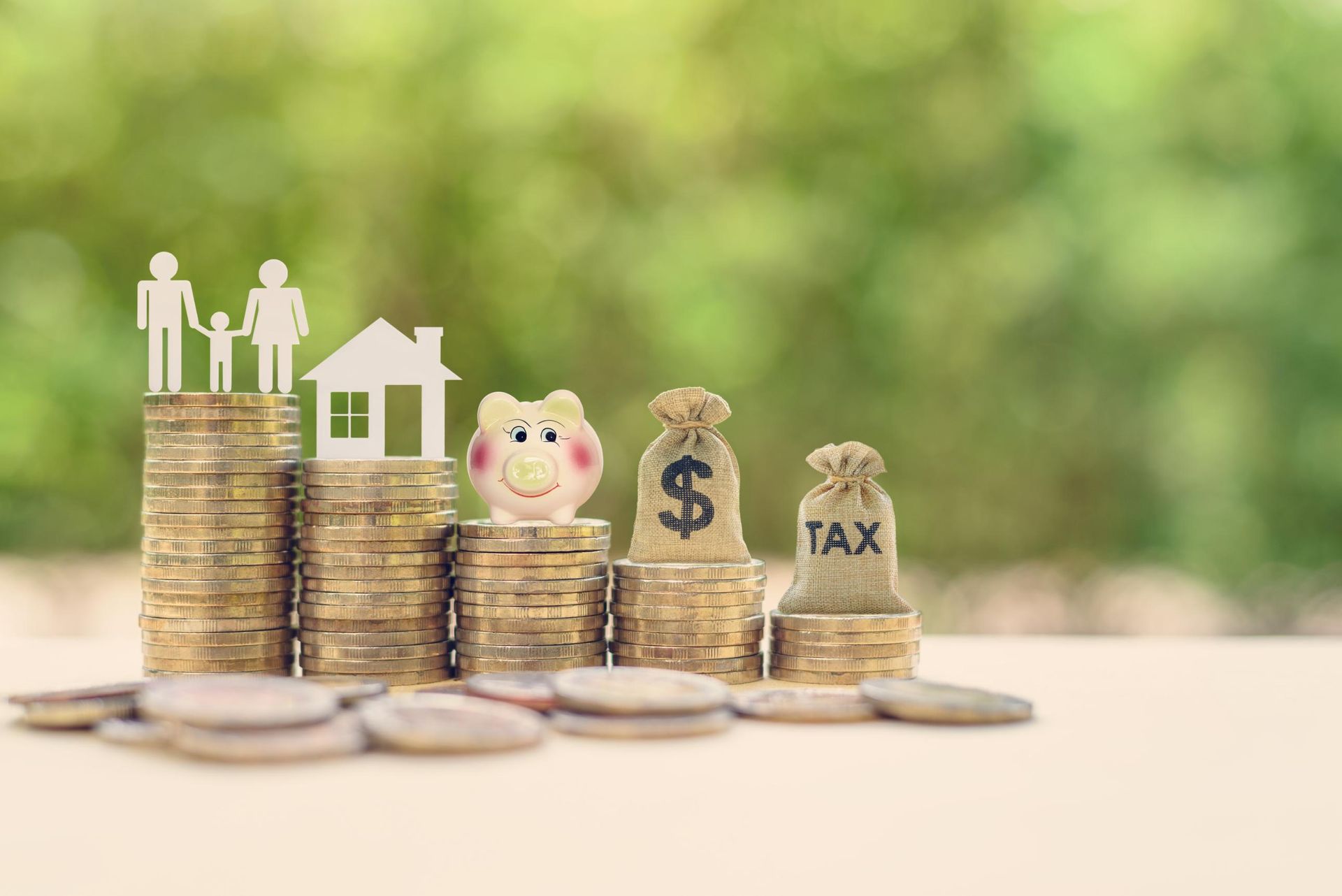 Stacks of coins with family, house, and money symbols.