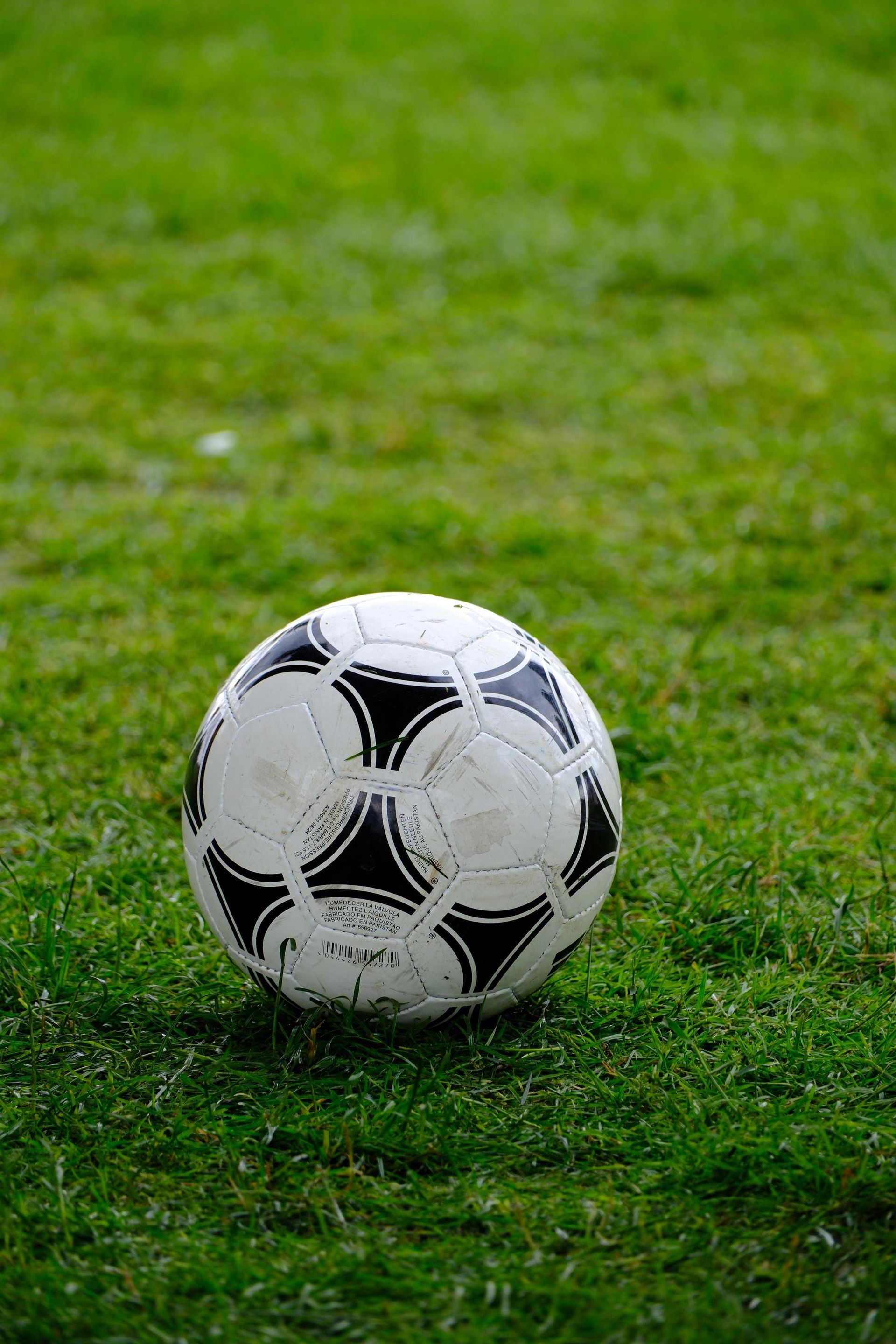 Black-and-white soccer ball on green grass field