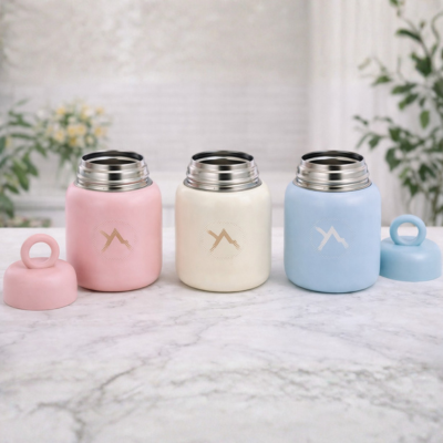 Tres frascos de comida térmicos de color pastel con tapa y logotipo de montaña.