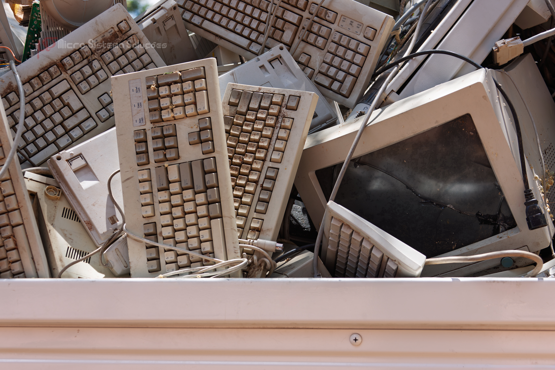 Pile of old computer keyboards and monitors.
