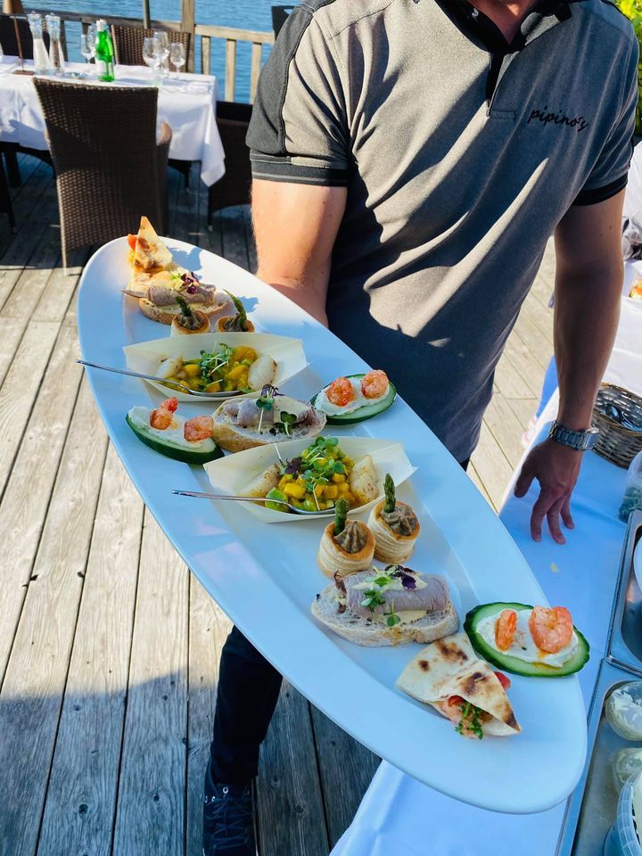 Hand hält Teller mit Speisen