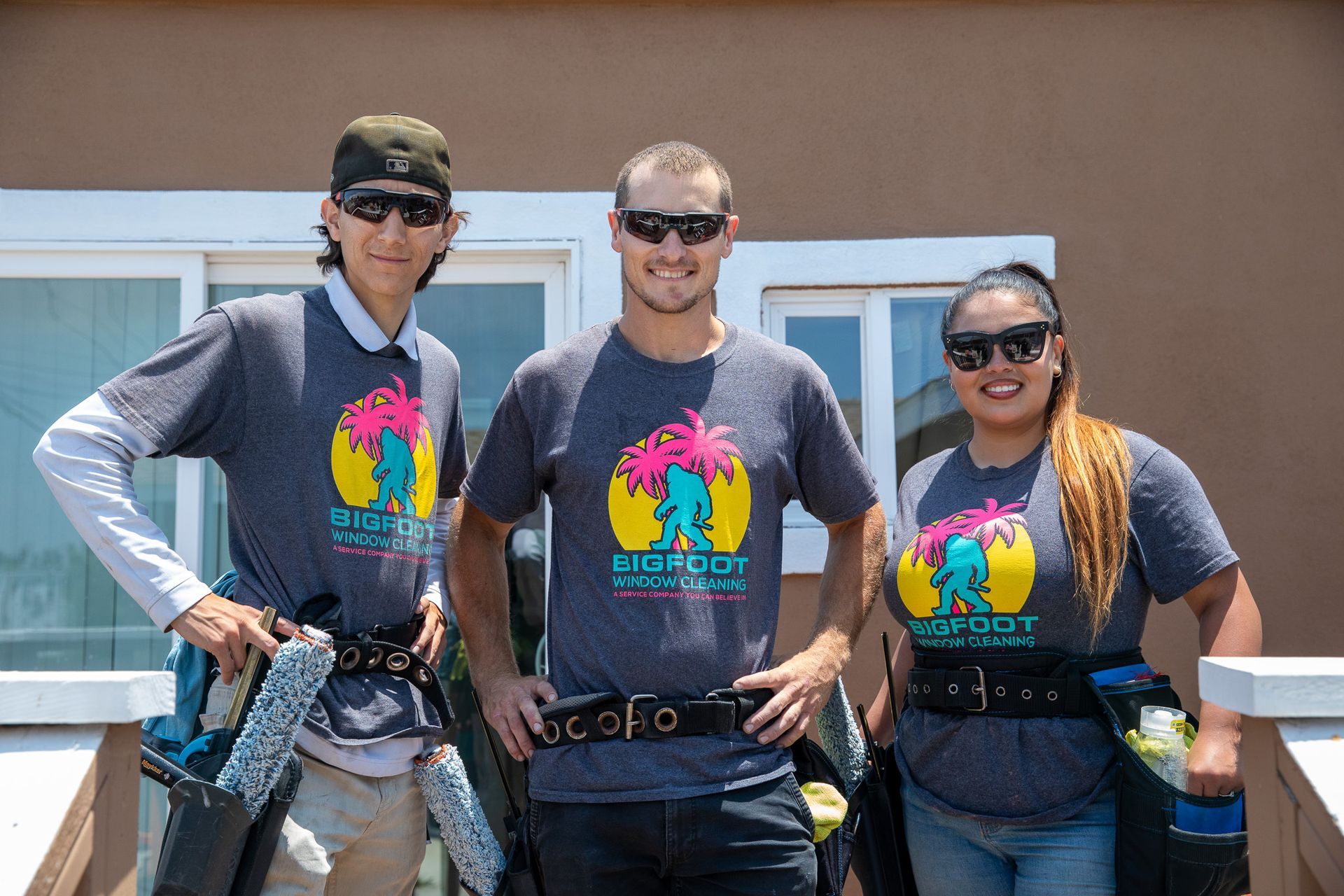 A group of three people standing next to each other in front of a building.