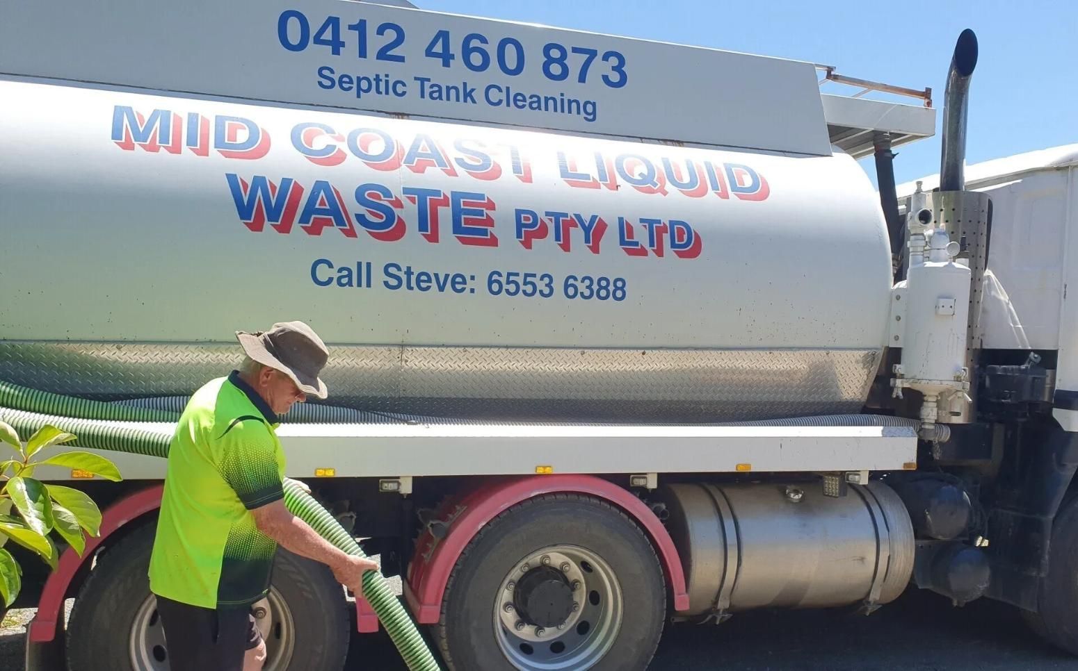 A Man is Pumping Water From a Truck — Mid Coast Liquid Waste In Old Bar, NSW