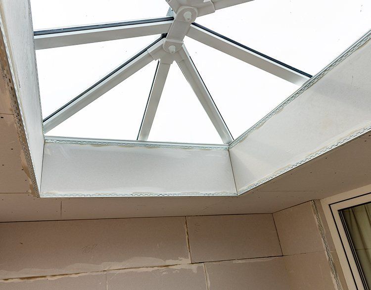 White skylight in a ceiling with white trim and beige walls.