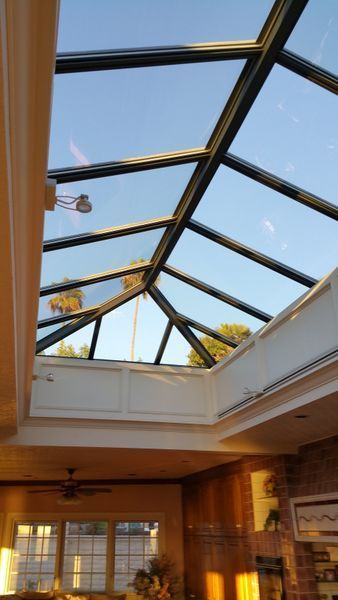 A room with a glass skylight, blue sky visible, and interior framing.