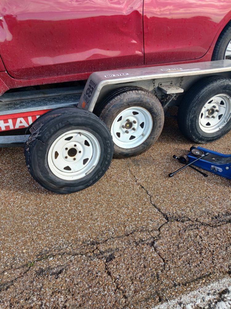 A red car is sitting on top of a trailer.