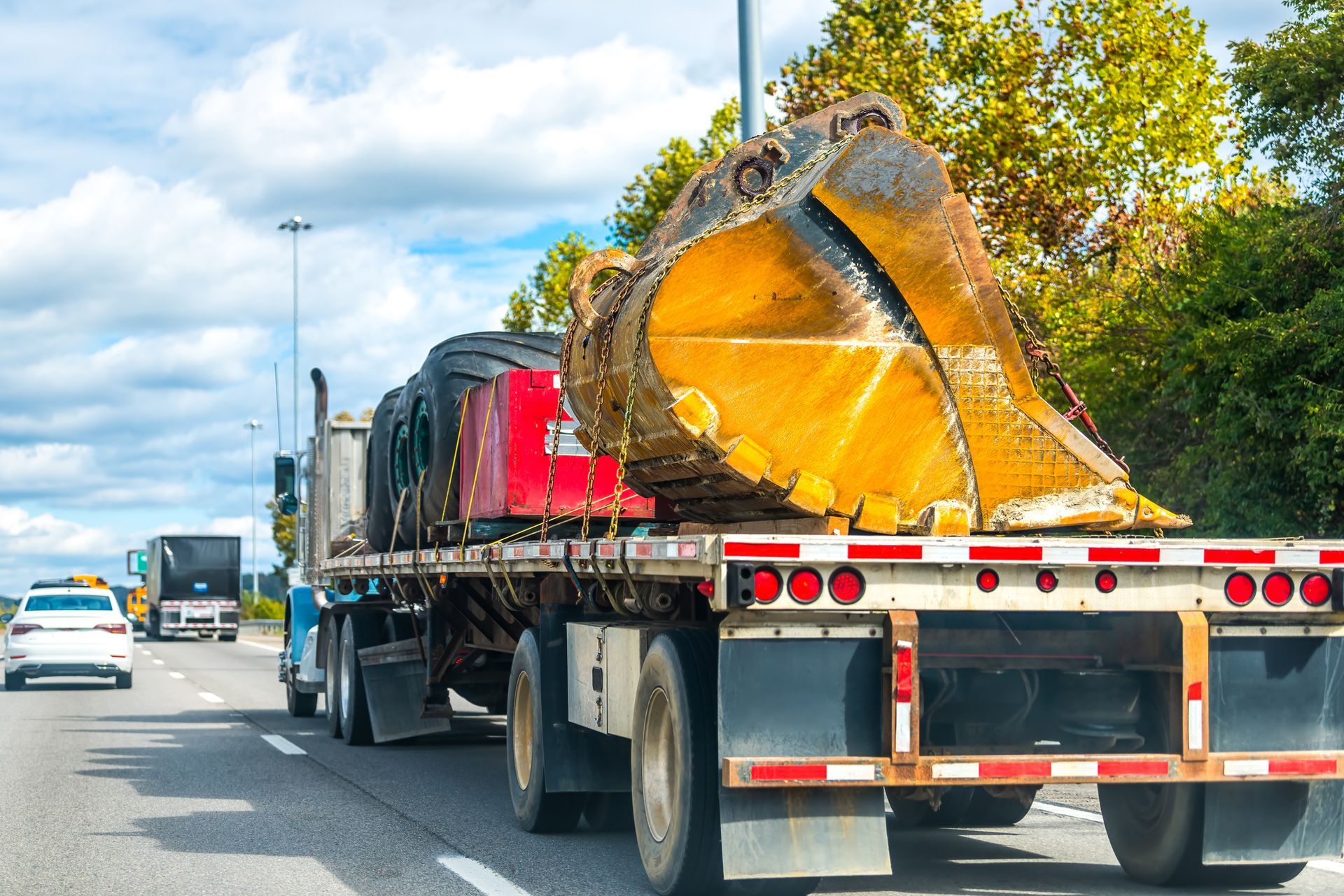 Cargo freight truck trailer shipping a hauling excavator machine.
