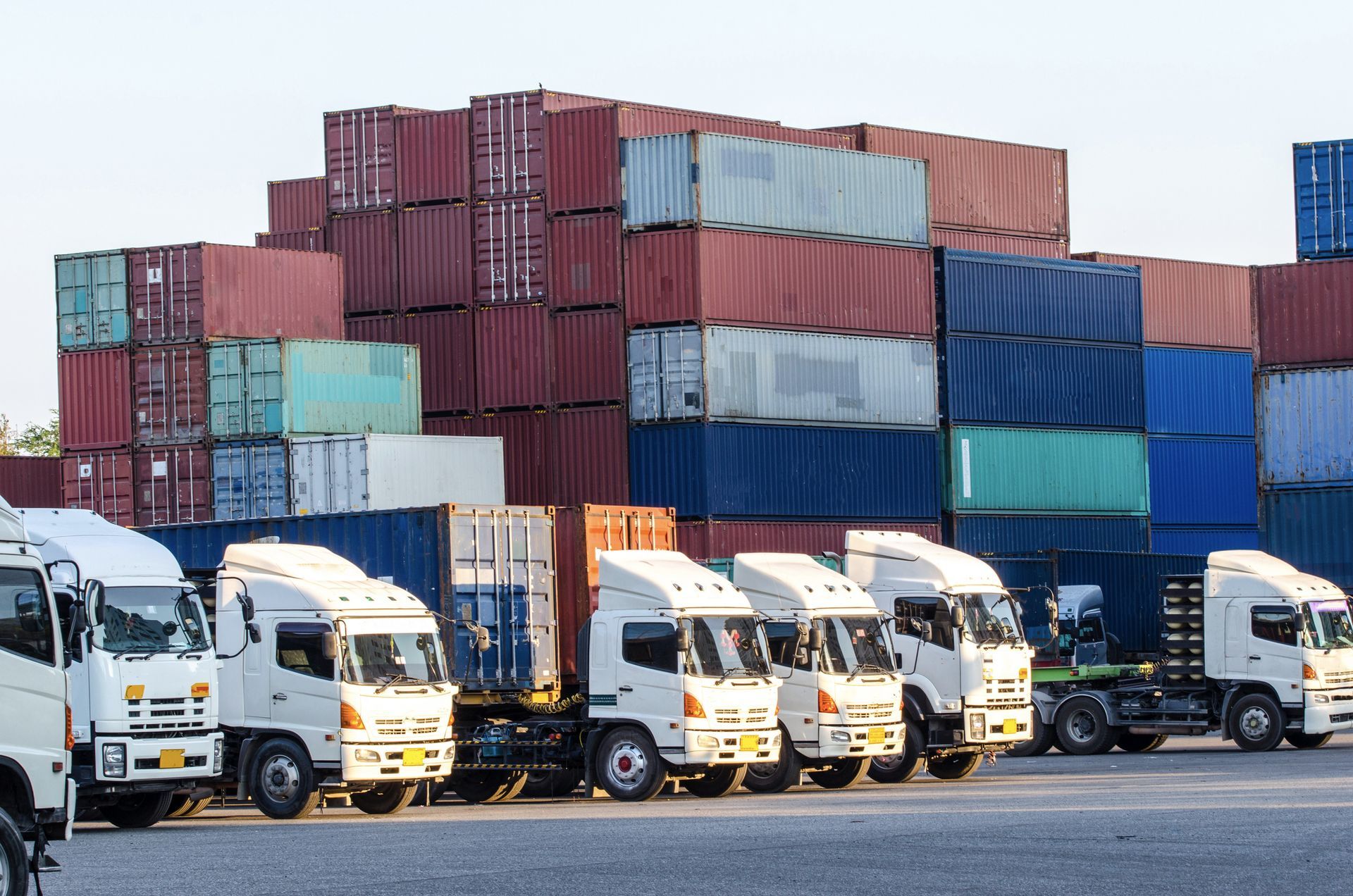Equipment hauling trucks lined up at industrial port ready for transport of heavy cargo.