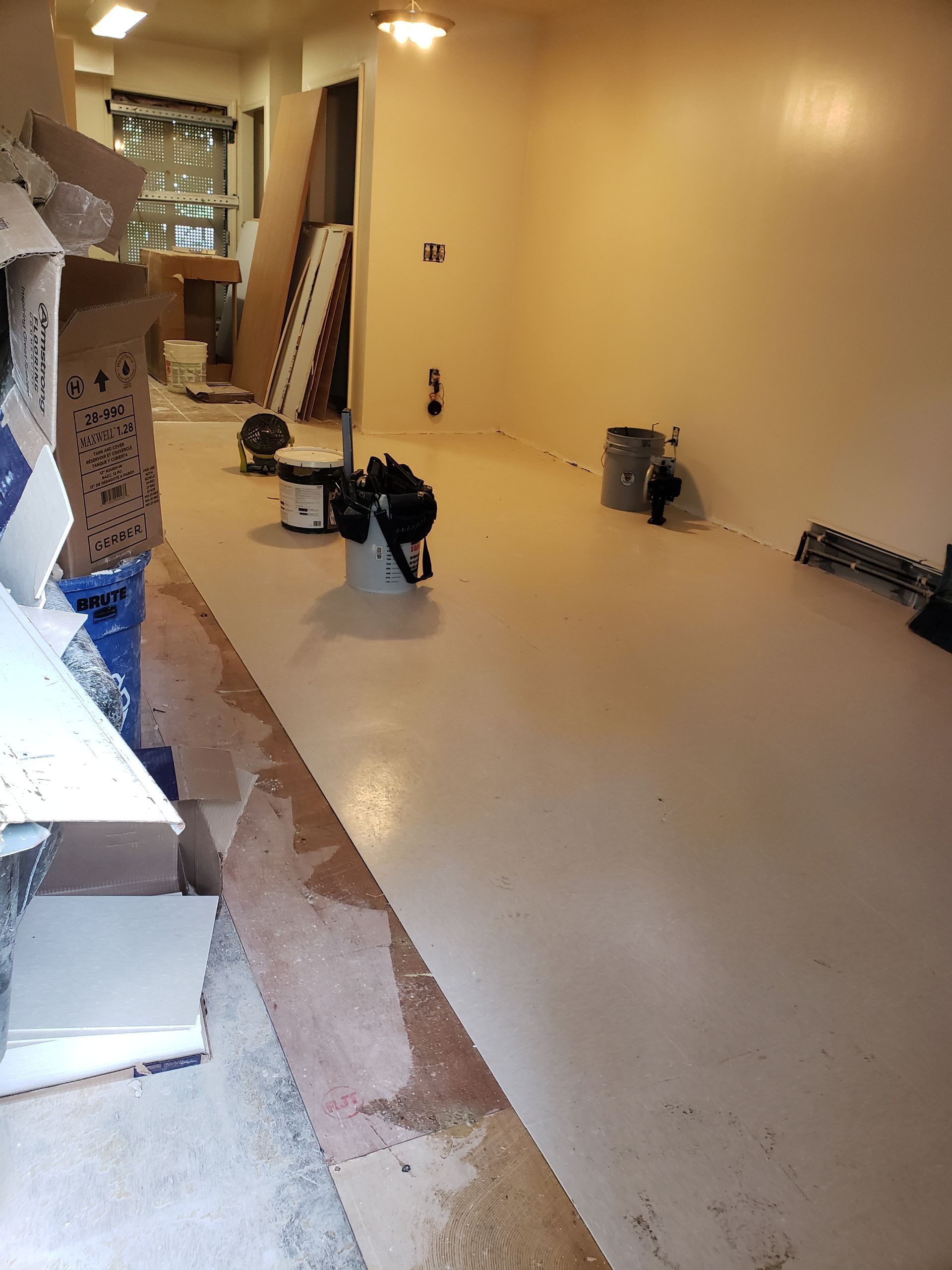 A room with a lot of boxes on the floor and a vacuum cleaner on the floor.