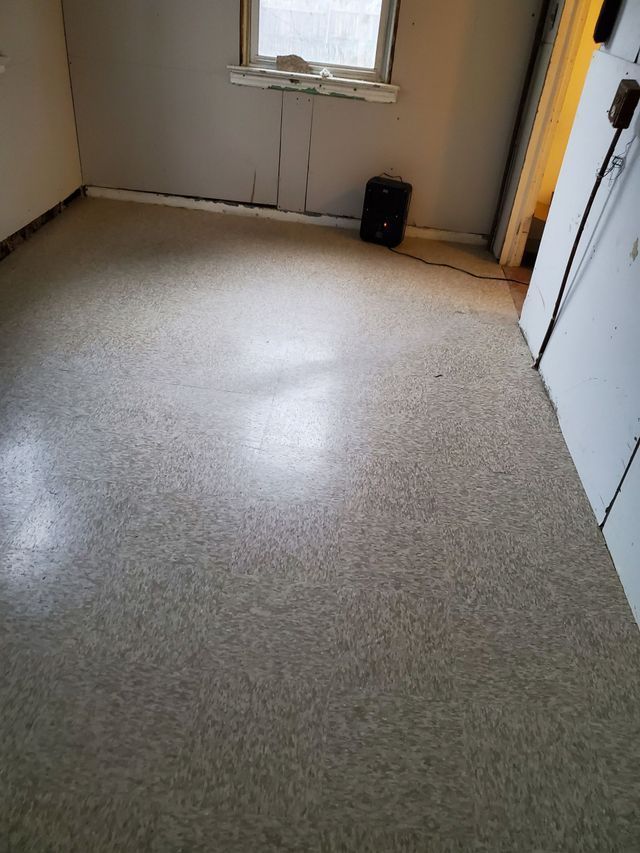 A room with a carpeted floor and a window.