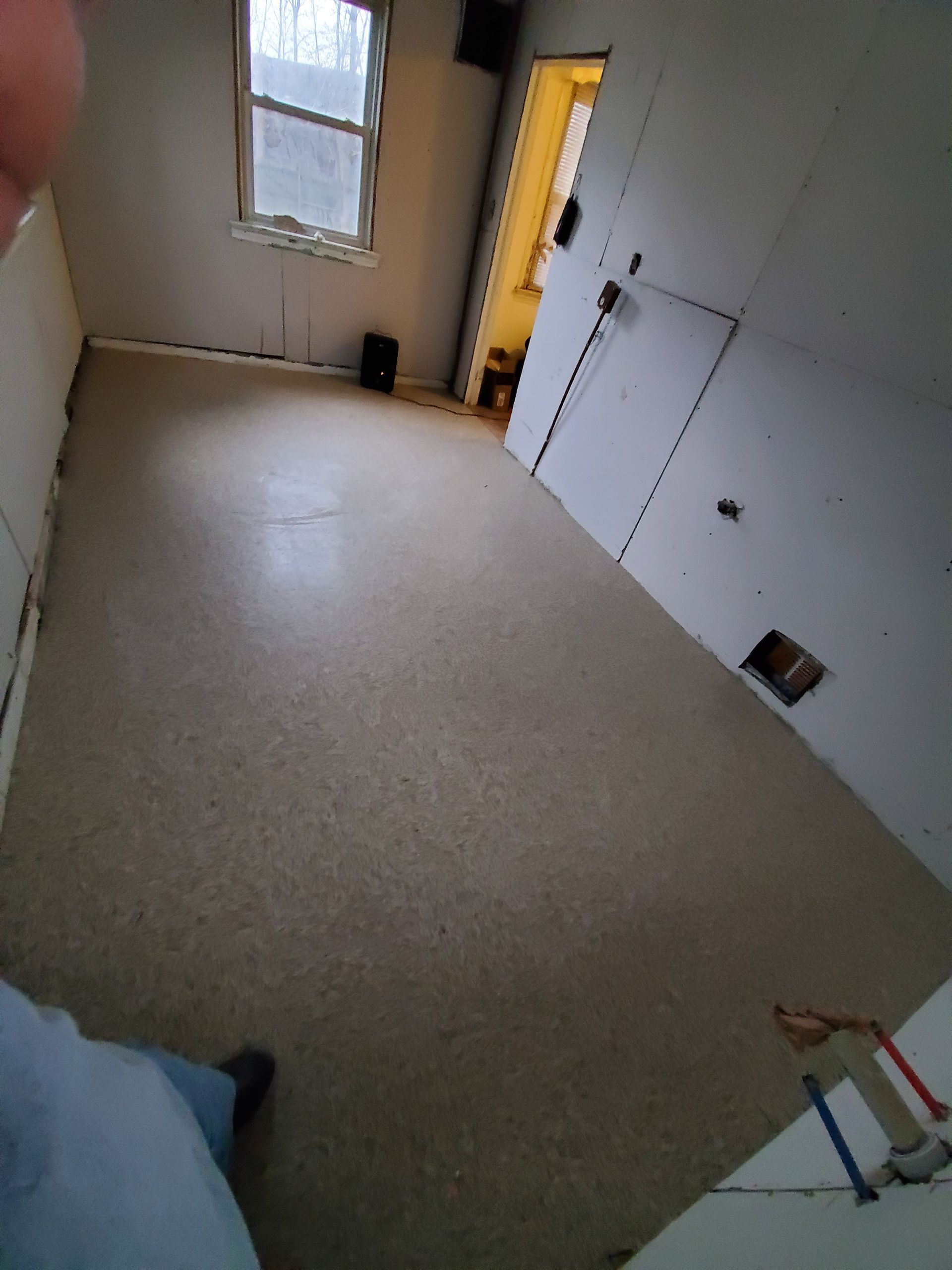 A room with a carpeted floor and a window