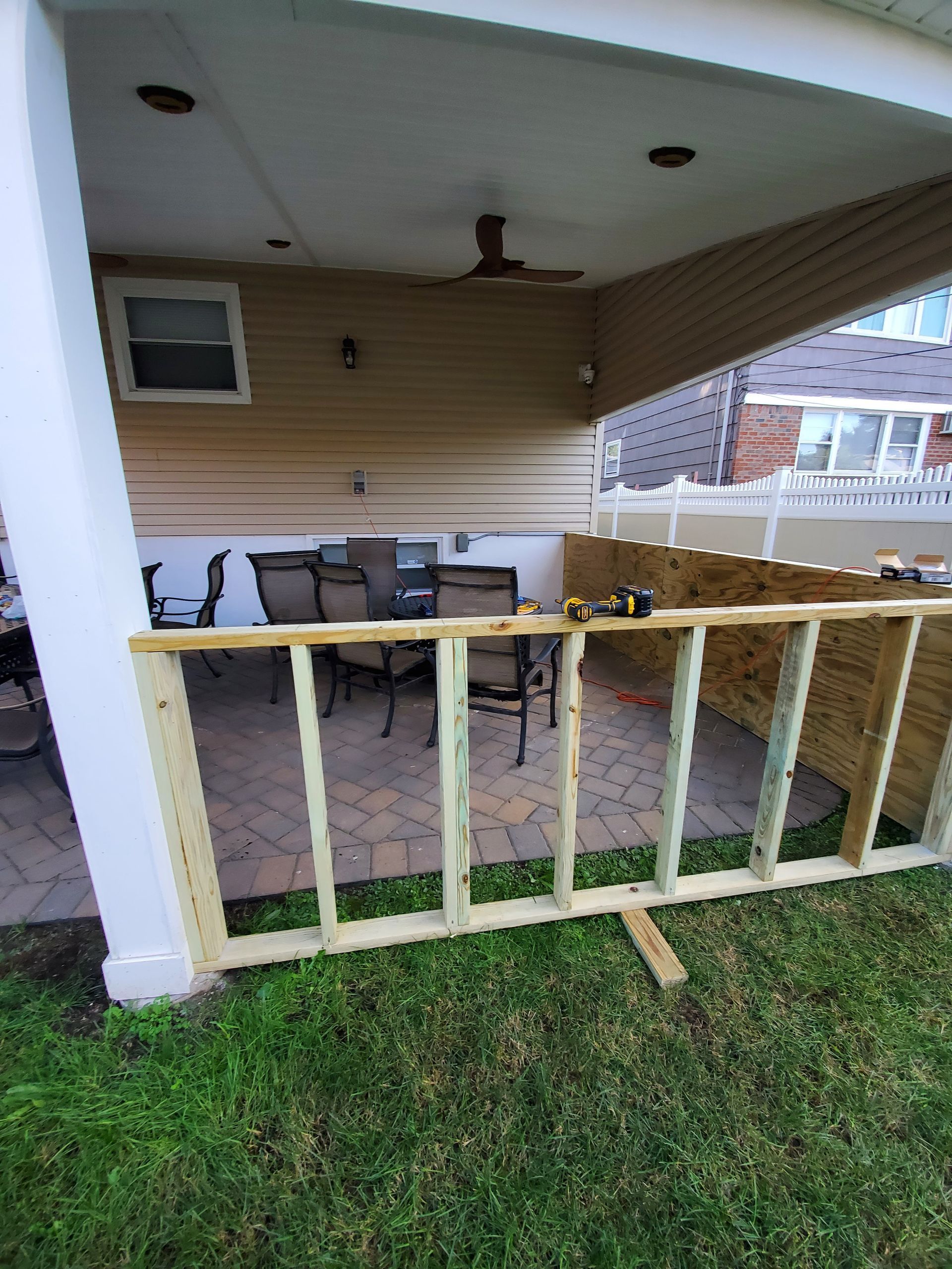A wooden deck is being built in the backyard of a house.